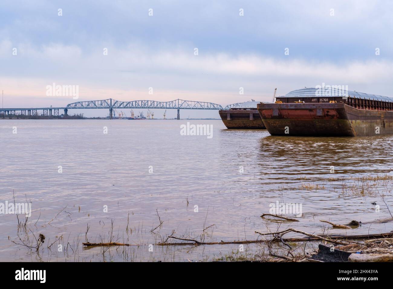 JEFFERSON, LA, USA - 3. MÄRZ 2022: Zwei Lastkähne dockten am Mississippi River mit der Huey P. Long Bridge im Hintergrund an Stockfoto