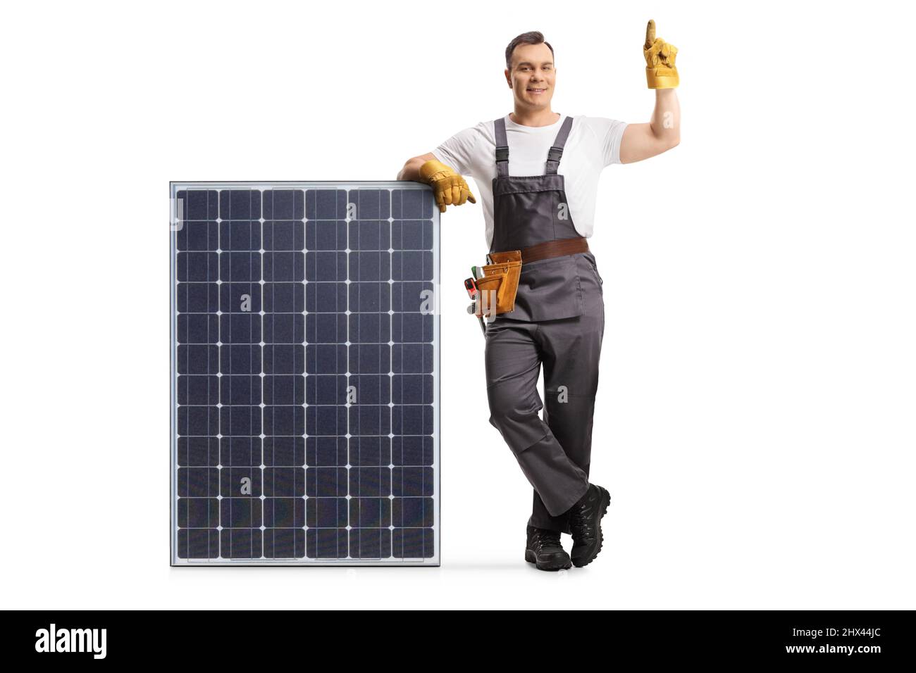 Porträt eines Technikers in einer Uniform, der sich auf ein Solarpanel stützt und isoliert auf weißem Hintergrund zeigt Stockfoto