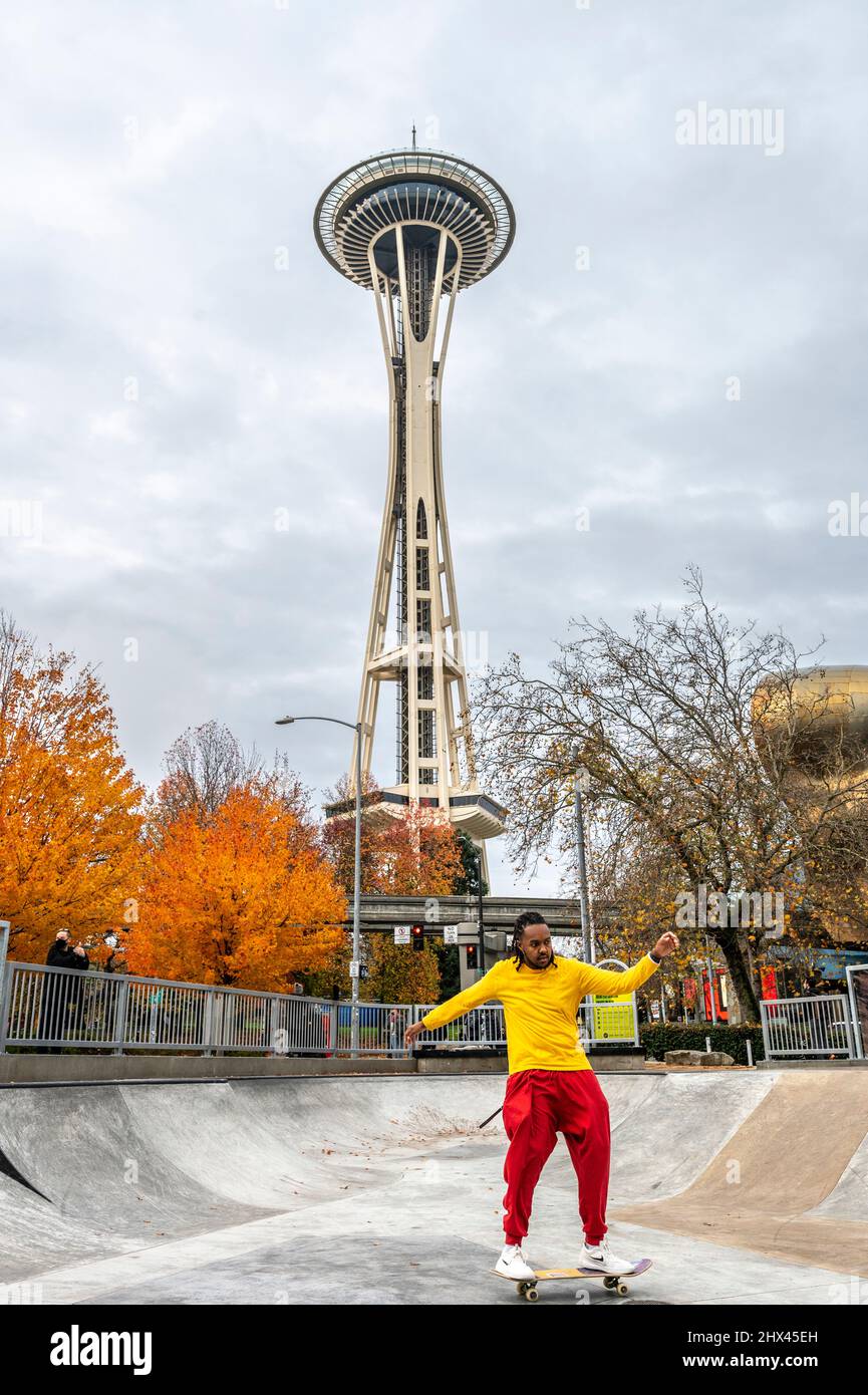 Man Skate Boarding in einem Skateboard Park im Seattle Center mit der Space Needle im Hintergrund Stockfoto