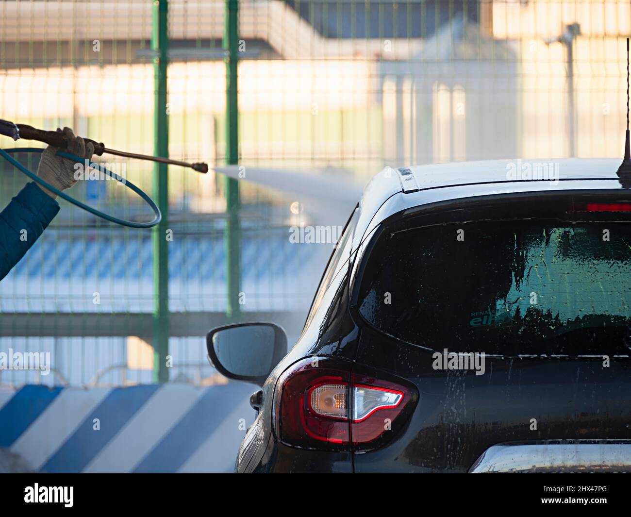 Ein Mann wäscht ein Auto an der Selbstwaschstation Stockfoto