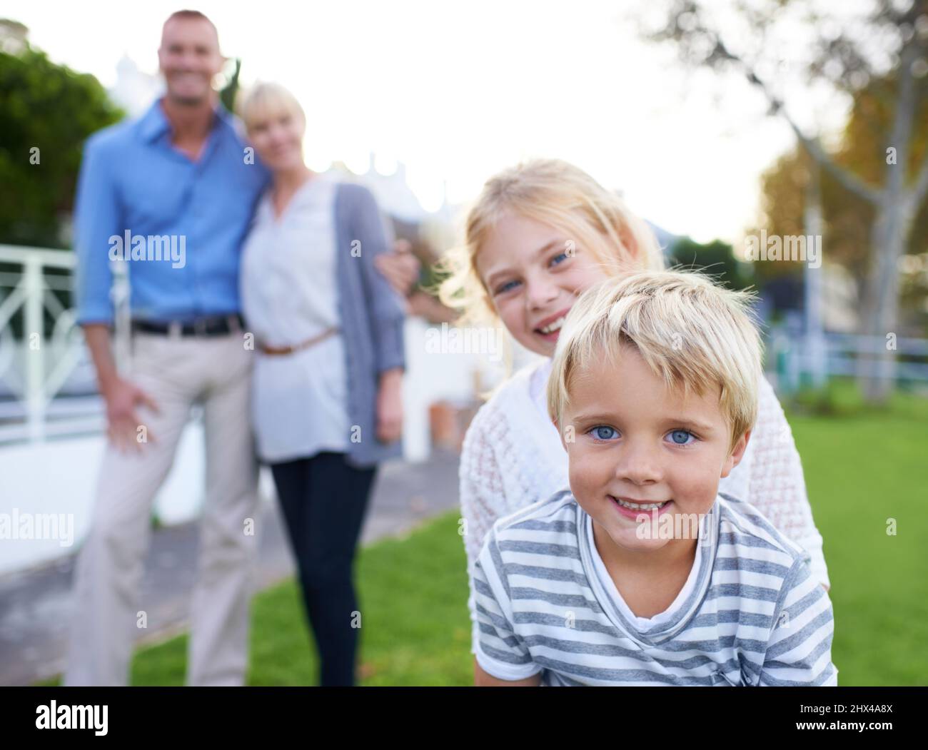 Wir sind so stolz auf unsere Kinder. Eine glückliche Familie in zwei Generationen, die im Freien lächelt. Stockfoto