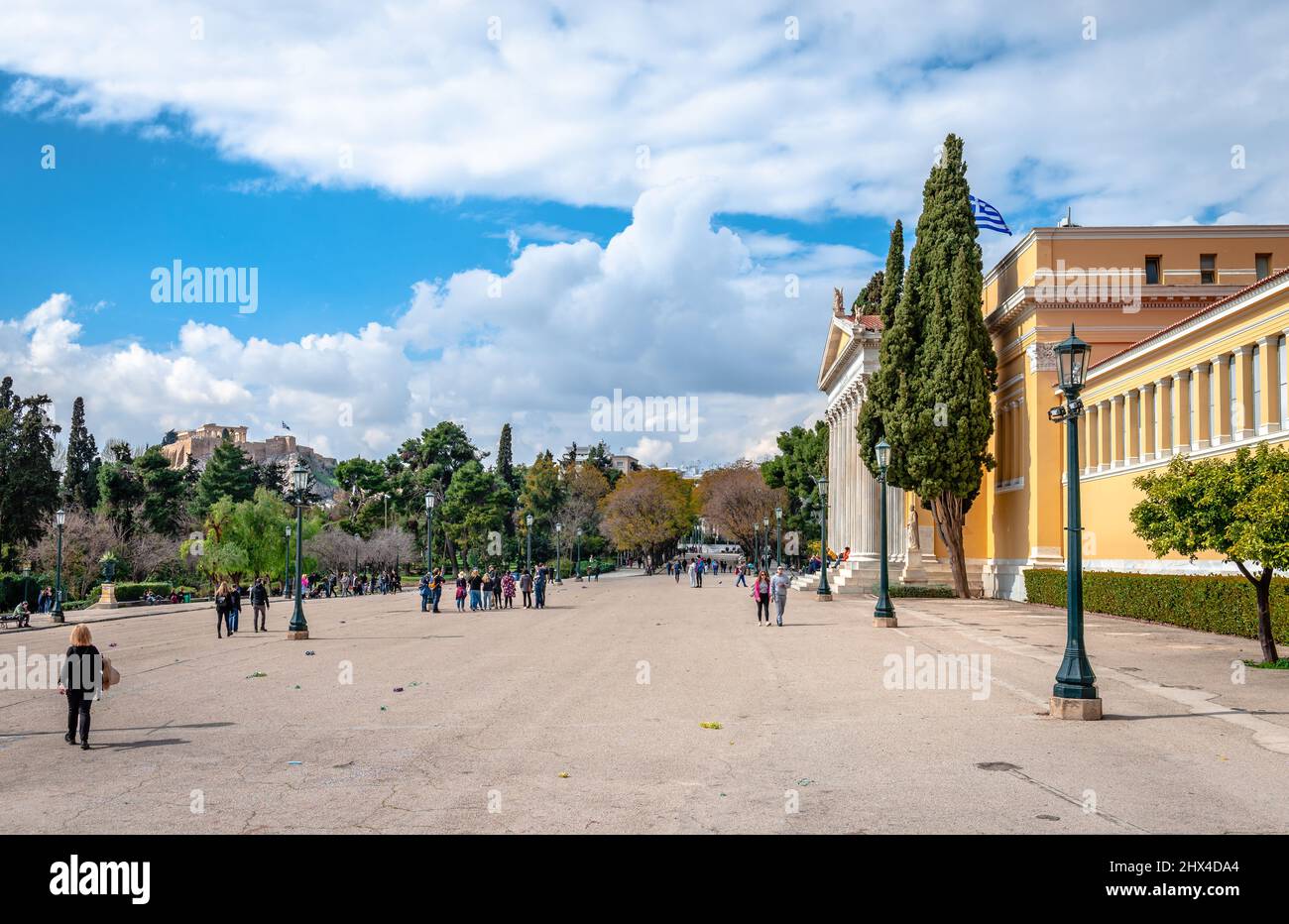 Athen, Griechenland - 6 2022. März: Die Menschen genießen einen sonnigen Nachmittag im Hof von Zappeio, mit der Akropolis im Hintergrund. Stockfoto