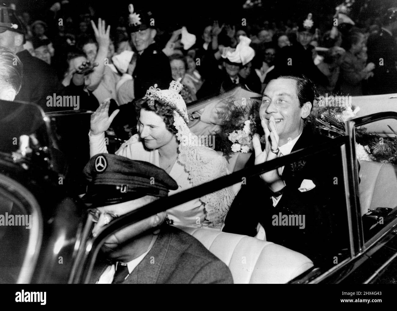 Ankunft zur Hochzeit - Prinz Ernst August von Hannover und Prinzessin Ortrud zu Schleswig-Holstein Sonderburg-Gluecksburg winken den jubelnden Massen bei der Ankunft in der Marktkirche hier für ihre kirchliche Hochzeit zu. 6. September 1951. Stockfoto