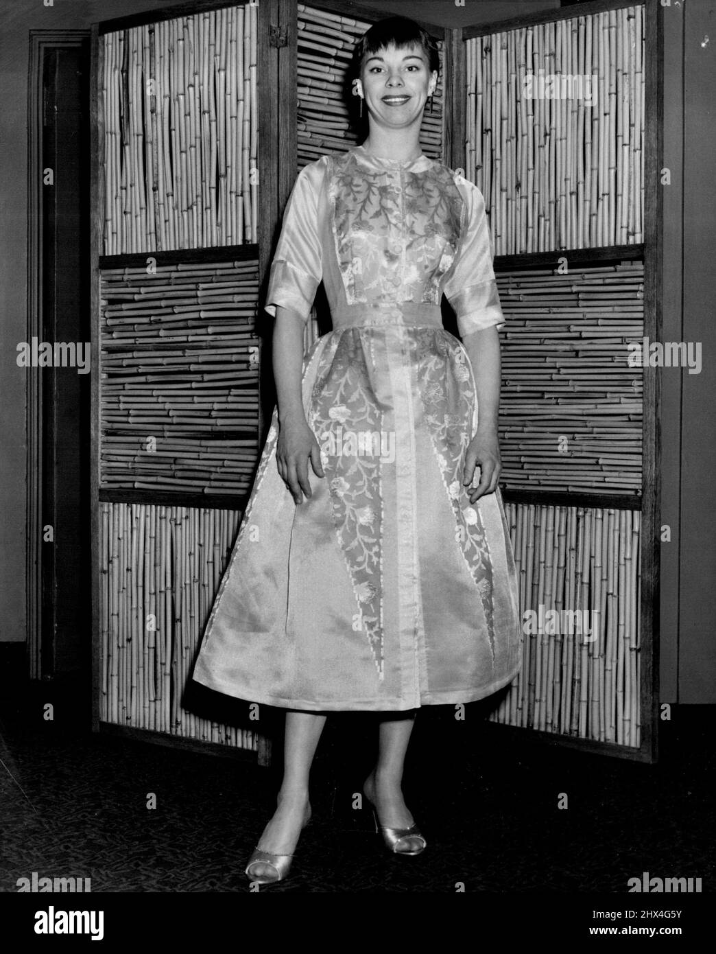 Carol Haney, von „Pajama Game“, wählt ein blumengeblümtes Seidenkleid in der alten französischen Hoflaune. Tina Leser ist die Designerin. 31. Januar 1955. (Foto von Don Ris). Stockfoto