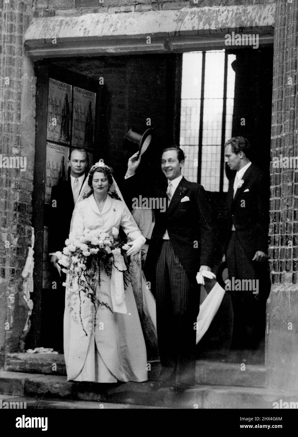 Prinzessin von Schleswig-Holstein Weds Prinz von Hannover - das Brautpaar vor der Marktkirche, Hannover, nach der Zeremonie. Mit dem Hochzeitsschleier der letzten deutschen Kaiserin ging Prinzessin Ortrud von Gluecksburg, die in der vergangenen Woche Prinz Ernst August von Hannover auf Schloss Marienburg in einer standesamtlichen Zeremonie heiratete, hier mit ihrem Mann durch die kirchliche Zeremonie. Der König und die Königin von Griechenland waren zu Gast bei der Zeremonie in der von Bomben beschädigten Marktkirche. 6. September 1951. Stockfoto