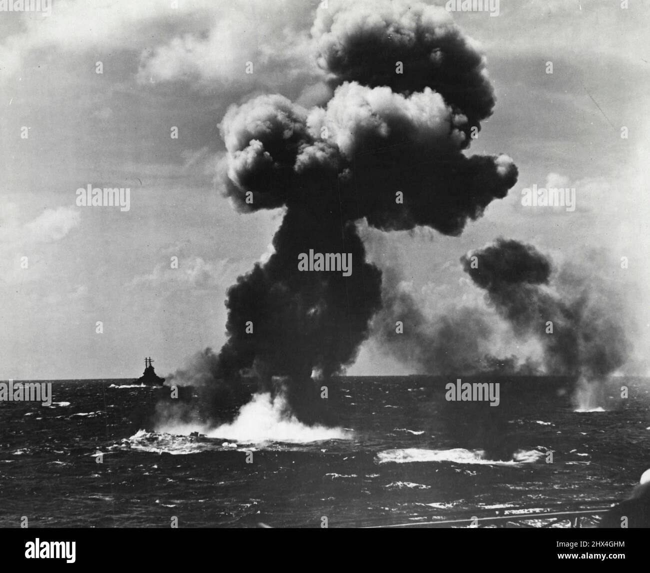 Ein Rauchschwaden markiert das wässrige Grab eines Jap-Torpedo-Flugzeugs, das nach einem Angriff auf die Marshallinseln vom 4. Dezember abgeschossen wurde, als er versuchte, einen Träger anzugreifen. Ein Zerstörer, der den Träger eskortiert, nähert sich im Hintergrund. Während der Aktion entfielen auf diese Task Force 72 feindliche Flugzeuge. 09. Dezember 1943. (Foto vom offiziellen US-Navy-Foto) Stockfoto