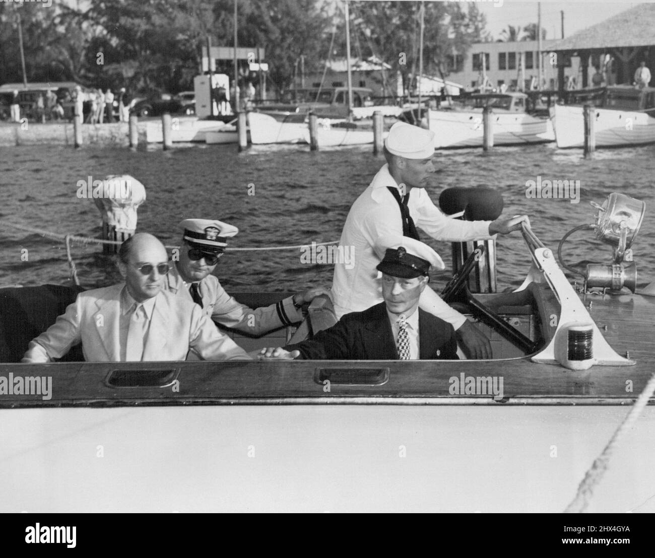 Navy Bomber reicht Duke of Roosevelt ein. Der Herzog von Windsor wird in einem Launch gezeigt, der ihn zu einem viermotorigen Navy-Bomber führt, der darauf wartet, ihn auf seine Mission zu tragen. Der Herzog sitzt auf dem Vordersitz, während sich ganz links sein Aide-De-Camp, Capt. Vyvyan Drury, befindet. 13. Dezember 1940. (Foto von ACME) Stockfoto