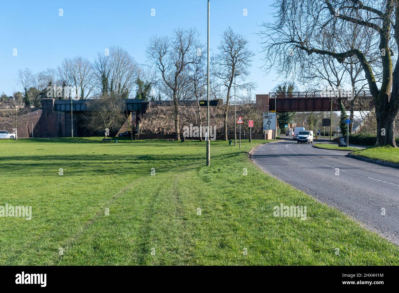 Zwei Eisenbahnbrücken an den Hinterhöfen, ein Grasdreieck, offener Raum für informelle Aktivitäten, in Alton Town, Hampshire, England, Großbritannien Stockfoto