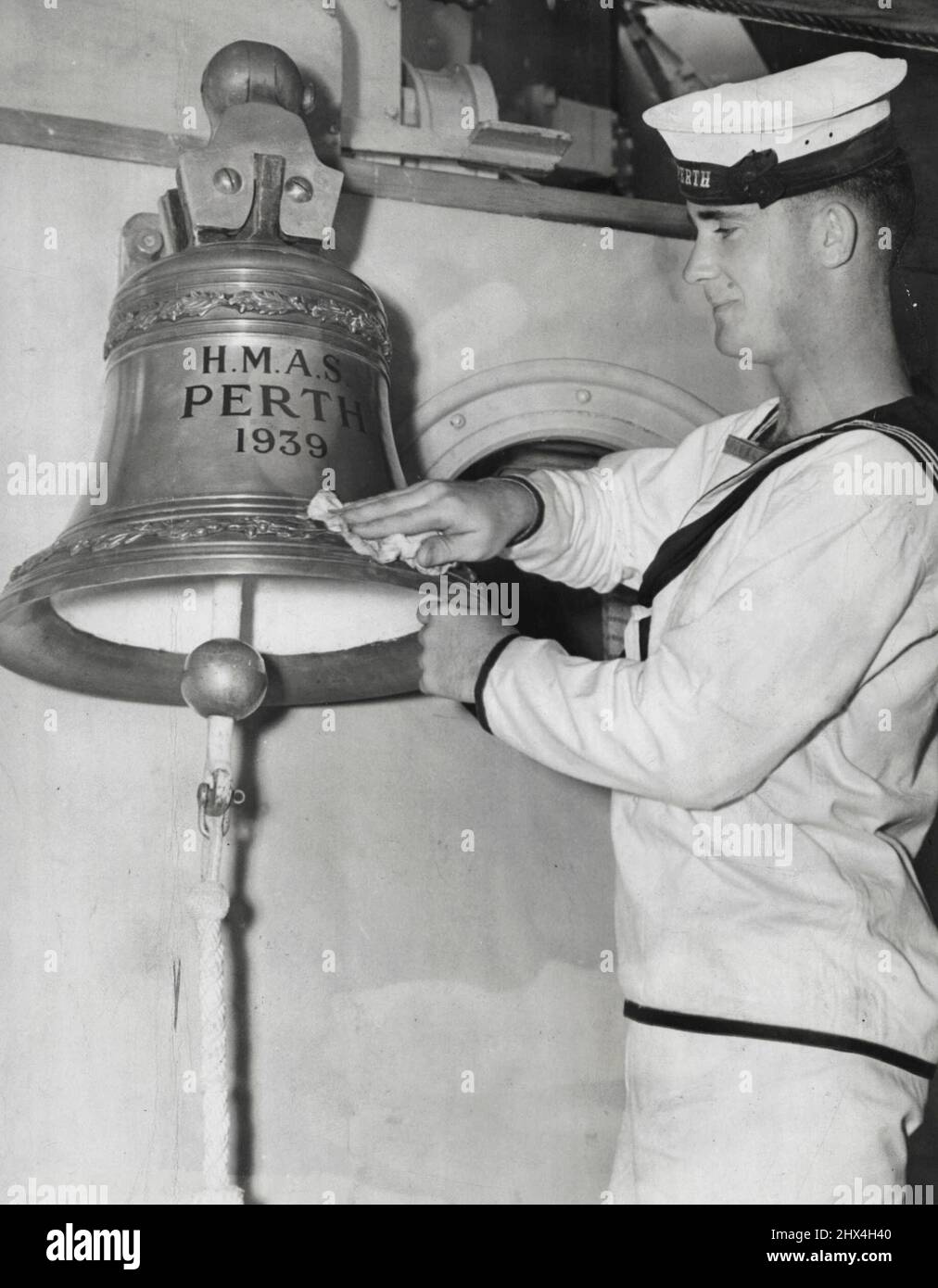 Der Glockentaucher Dave Burchell sucht am Fuße der Sunda Strait: Foto der Vorkriegszeit. Seemann Ron Boyis, von H.M.A.S. Perth poliert die Glocke des Kreuzers während ihres Besuchs in New York auf dem Weg nach Australien. 26. August 1939. (Foto von Associated Press Photo). Stockfoto