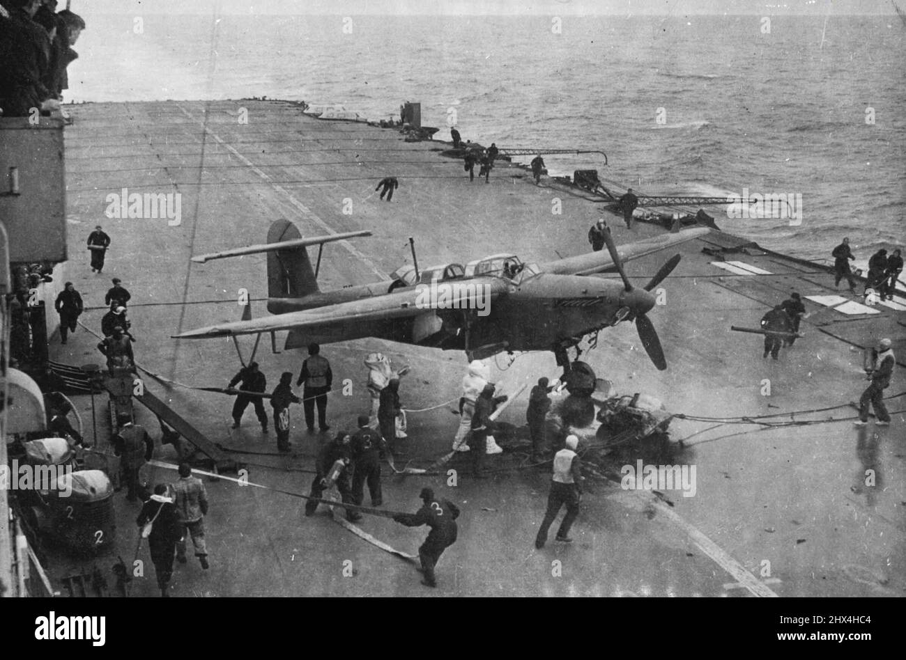 Fleet Air Arm trifft den 'Tirpitz' - Ein 'Barracuda', der von feindlicher Flak auf dem Flugdock abgeflossen ist, während die Feuerpartei in Aktion getreten ist. An Bord eines Royal Naval-Flugzeugträgers während einer weiteren erfolgreichen Operation gegen das deutsche Schlachtschiff „Tirpitz“ und die feindliche Schifffahrt vor Norwegen. 01. September 1944. (Foto von British Official Photograph). Stockfoto