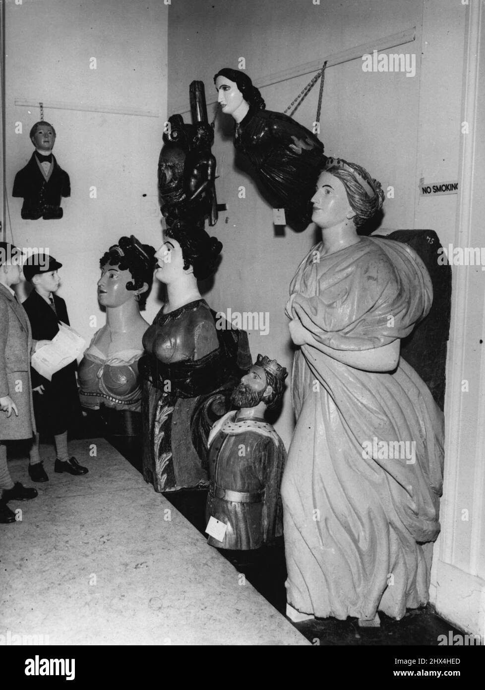 Ausstellung der Schiffskantchen - Hier sehen Terry und Timothy Stanton einige der alten Galionsfiguren. Am Montag wird im National Maritime Museum in Greenwich eine Ausstellung mit Galionsfiguren aus alten Handelsschiffen eröffnet. 30. Oktober 1953. (Foto von Daily Mail Contract Picture). Stockfoto