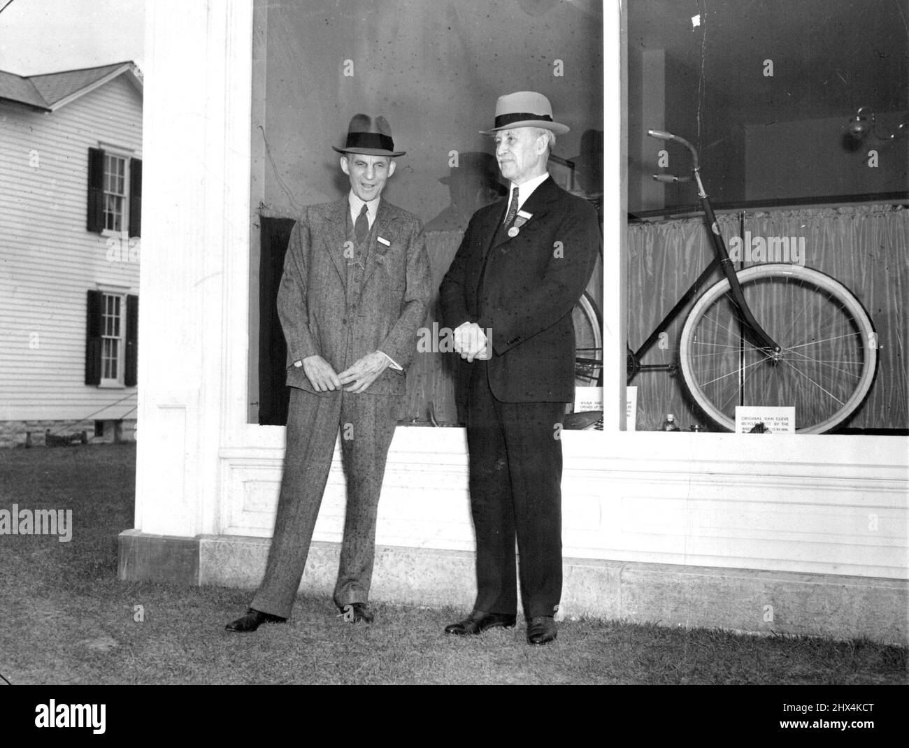 Transportation Pioneers -- Henry Ford (links), Automobilpionier, begrüßte Orville Wright (rechts), Exponent der frühen Luftfahrt, April 16 vor dem Fahrradladen, in dem rechts und sein Bruder, der verstorbene Wilbur rechts, die ***** bauten Schwerere Flugmaschine als Luft. Es war in Detroit, Michigan., wo der Wright-Laden und das Haus, das von Dayton, O., von ford dorthin gebracht wurde, formell eingeweiht wurden. 17. April 1938. (Foto von Associated Press Photo). Stockfoto