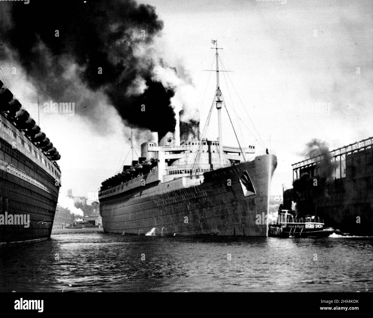 S.S. Queen Mary verlässt auf Mystery Trip – der riesige Liner verlässt heute ihren Pier unter versiegelten Befehlen. Es wurde gemunkelt, dass der 81.000-Tonnen-Liner australische Truppen in den Nahen Osten transportieren wird. Der Liner war ohne ihre luxuriösen Passform, als sie heute auf See ging. Es wird angenommen, dass ein Konvoi britischer Kampfschiffe auf See wartet, um die Queen Mary auf ihrer Mystery-Reise zu bewachen. 21. März 1940. (Foto von Wide World Photo). Stockfoto