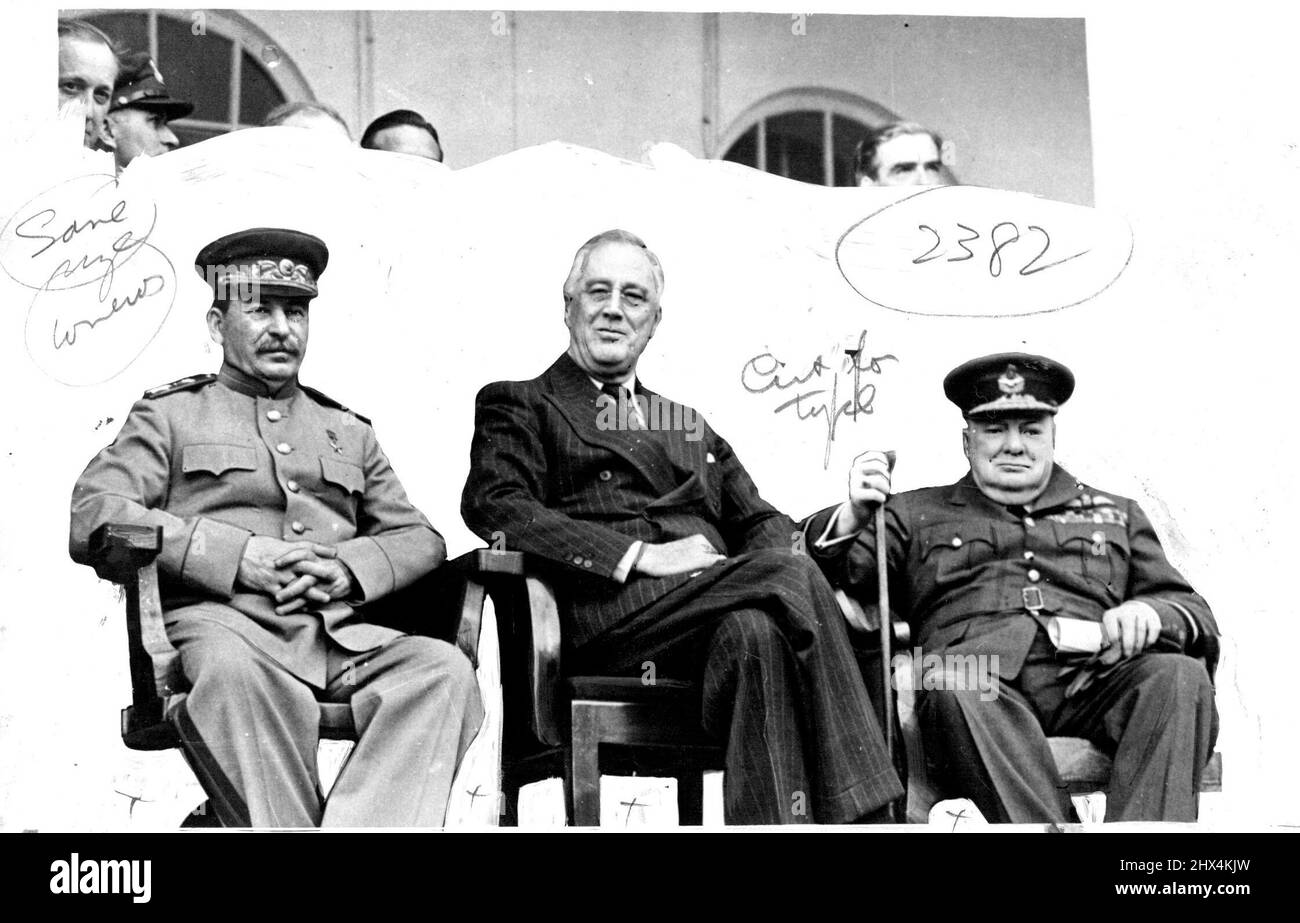 Wir drei -- Marschall Stalin, Präsident Roosevelt und Churchill bei ihrem Treffen in Teheran, der Hauptstadt Persiens. Mit ihnen im Rücken kann scheinen:- Mr. Molotov, Mr. Antony Eden und Sektionsleiterin Mrs Oliver, Tochter von Mr. Churchill. 22. Februar 1944. (Foto von L.N.A.). Stockfoto