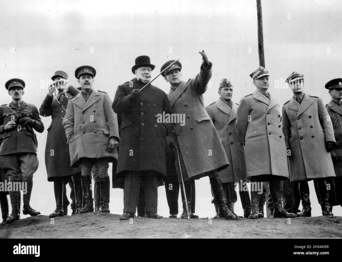 Premierminister bei der Panzerdemonstration -- der Premierminister hat kürzlich eine Panzerdemonstration erlebt, bei der ihm die Fähigkeiten verschiedener gepanzerter Kampffahrzeuge über raues Land gezeigt wurde. Mit ihm waren General de Gaulle, (G.O.C. Freie Französische Streitkräfte). Der Premierminister beobachtet die „Schlacht“ von einem Hügel aus. Auf der linken Seite ist General de Gaulle und auf der rechten Seite General Sikorski. 18. April 1941. (Foto von British Official Photograph). Stockfoto