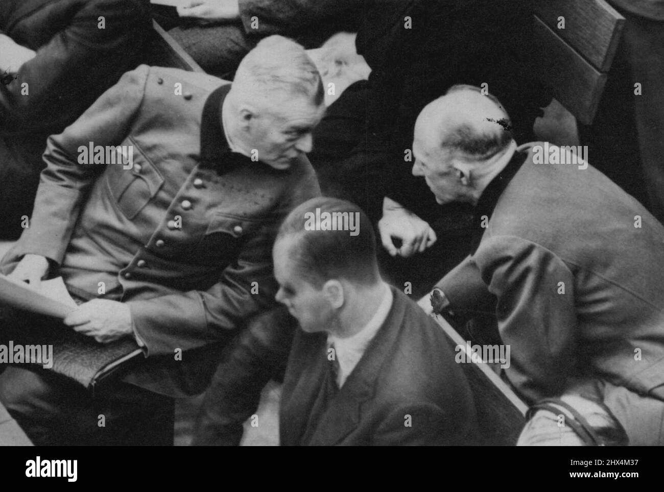 Angeklagte des Nürnberger Prozesses -- Gen. Alfred Jodl (rechts) und Gen. Wilhelm Keitel drehen sich um zu ***** Im Kasten der Angeklagten während des ***** Die Prozesse in Nürnberg, Deutschland. 27. November 1945. (Foto von Associated Press Photo). Stockfoto