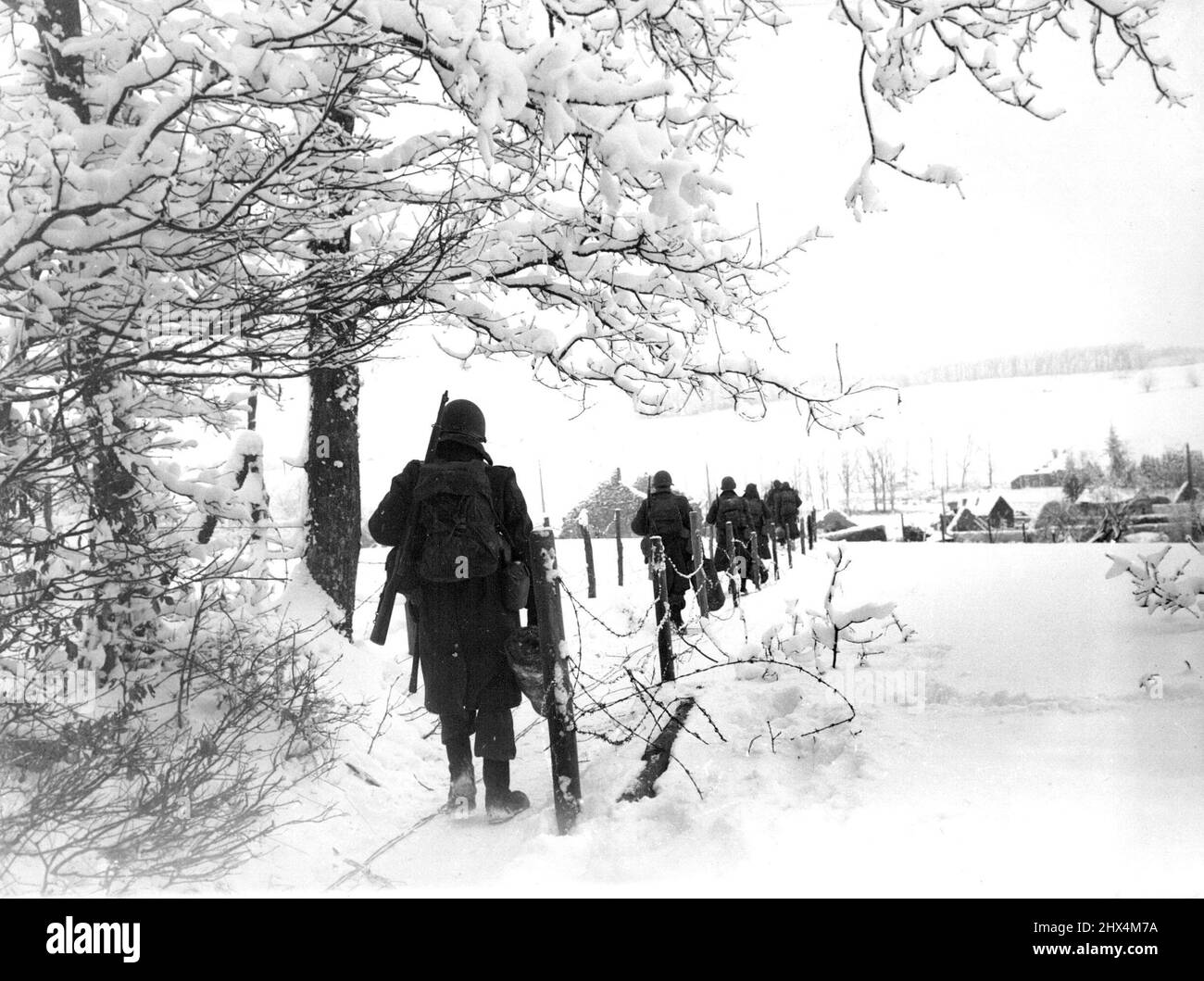 Yanks auf dem Marsch durch Schneefelder in Belgien Eine Kolonne von Soldaten der dritten US-Armee marschiert durch schneebedeckte Ländereien in Belgien, um das Dorf Lutrebois zu besetzen. 24. Januar 1945. (Foto von Bryon H.Rollins, Associated Press). Stockfoto