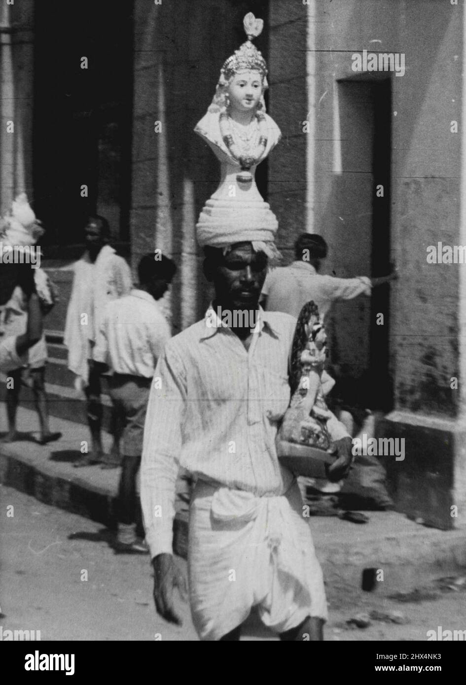 Nicht der neueste Stil in Kopfschmuck, sondern nur eine bequeme Möglichkeit, um mit Ihren Waren zu umgehen! Madras Straßenhändler geht auf die Suche nach Käufern für seine Gipsabgüsse, die von Königin Victoria zu sein scheinen. 1.Mai 1952. (Foto von Daily Mirror). Stockfoto