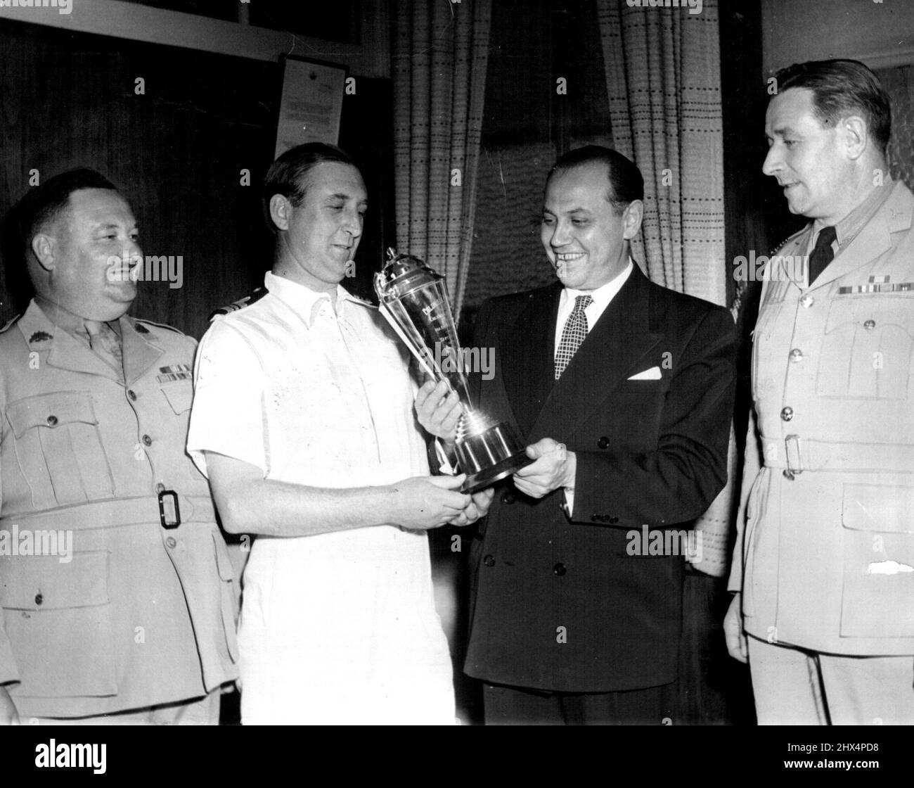 Präsentation der Trophäe durch N. P Pery, Managing Director, Columbia Picters, für den Wettbewerb zwischen Marine, Armee und Luftwaffe bei Streckenveranstaltungen in Australien. (Von links nach rechts) Major Willington, Army Americans Officer; Lieutenant-Commander Cooper, Port Recreation Officer; N.P. Perry, Managing Director, Columbia Picters; Wing-Commander Clarke-Taylor, R.A.A.F. Ausstattung Officer. 25. November 1950. Stockfoto