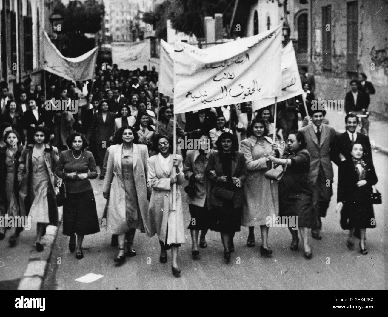 Ägyptische Suffragettes: Die Prozession auf dem Weg von der Universität zum parlamentsgebäude. Auf dem Banner an der Vorderseite steht: „Frauengruppen fordern politische Rechte für Frauen“. Die Polizei schloss am 19. Februar die Türen des parlamentsgebäudes in Kairo, als nach einem Treffen der ägyptischen Feministischen Partei in der Ewart Memorial Hall der American University schätzungsweise 500 Demonstranten versuchten, das Gebäude zu betreten, um politische Rechte einzufordern. 7. März 1951. (Foto von Associated Press Photo). Stockfoto