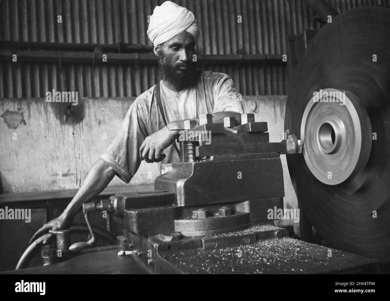 In Einer Big Indian Tinplate Mill -- Sikh-Operator auf einer Drehmaschine in der Maschinenhalle. 5. August 1953. Stockfoto