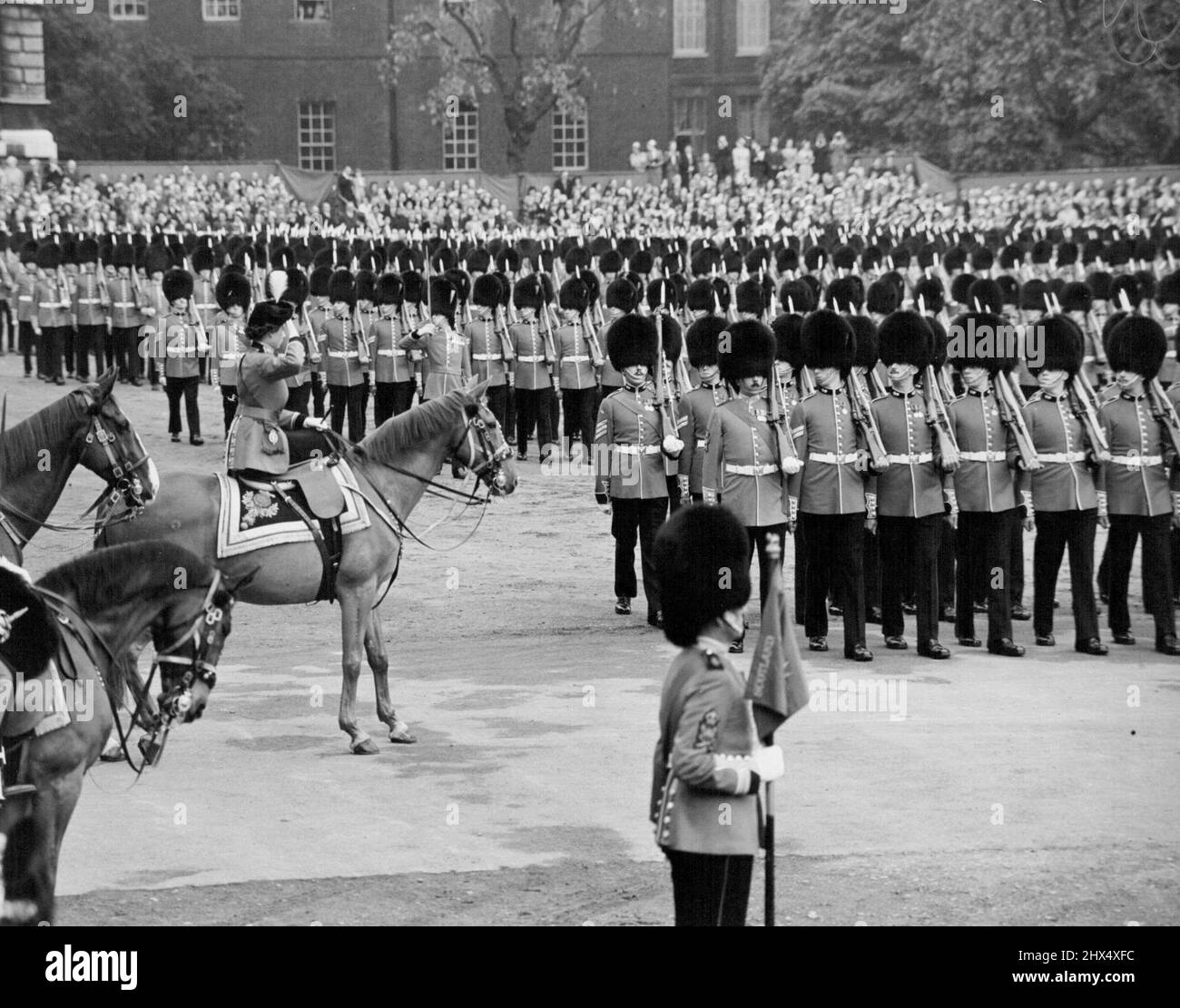 Königin bei der Parade der Pferdewächter bei der Zeremonie der „Trooping the Colour“. Die Königin ritt heute vom Buchingham Palast, um den Gruß bei der Parade der Farbstreitzeremonie auf der Horse Guards zu feiern. Rekordmassen säumten den Weg, um die Königin vorbeiziehen zu sehen, und seit den frühen Morgenstunden hatten die Menschen auf die Parade der Pferdewache gewartet, um die Zeremonie zu sehen. Die Königin ritt auf dem Polizeipferd Winston einen Seitensattel und trug ihre speziell entworfene Garde-Uniform - eine scharlachrote Tunika, einen dunkelblauen Reitrock und einen Tricorne-Hut mit dem goldenen Abzeichen und der weißen Wolke der Grenadiere. Hinter dem Qu Stockfoto