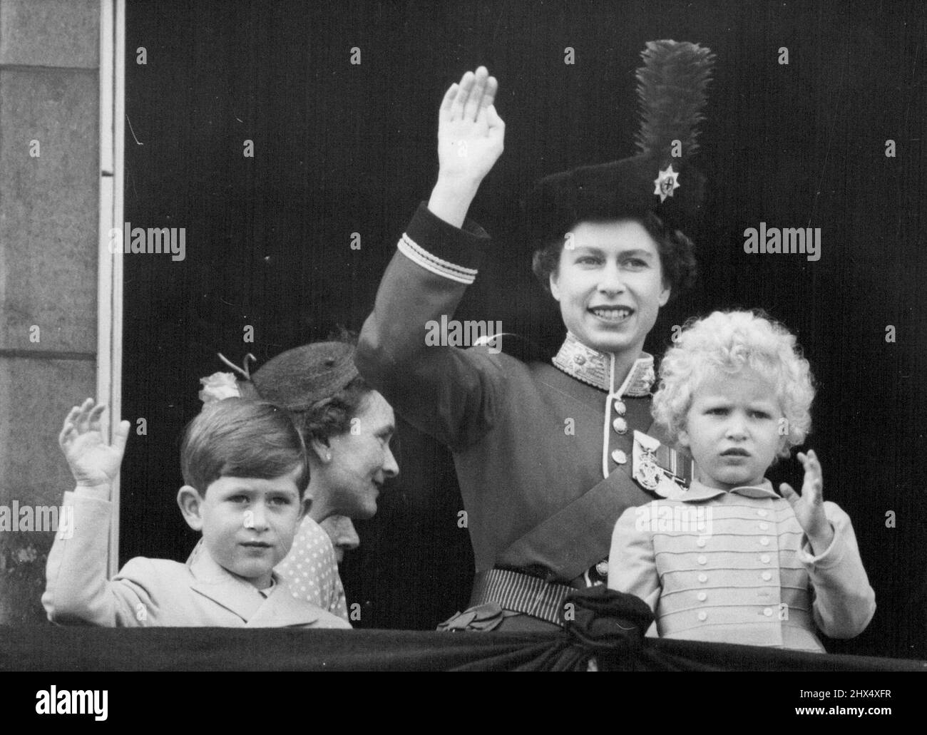 Königin und Kinder winken nach dem „Trooping“ vom Balkon – die Königin, Prinz Charles und Prinzessin Anne winken aus dem Balkon des Buckingham-Palastes, nachdem die Königin nach der traditionellen Parade der „Trooping the Color Ceremony on Horse Guards“ auf den Balkon des Palastes zurückgekehrt war. Von den Balkonmitgliedern der königlichen Familie aus sahen die Balkonmitglieder der königlichen Familie einen Vorbeiflug von drei Staffeln von Düsenflugzeugen der königlichen Hilfsluftwaffe - die erste Gelegenheit, bei der die Hilfsluftwaffe die Ehre erhielt. Die Königin trägt ihre scharlachrote Tunika und dunkelblau Stockfoto