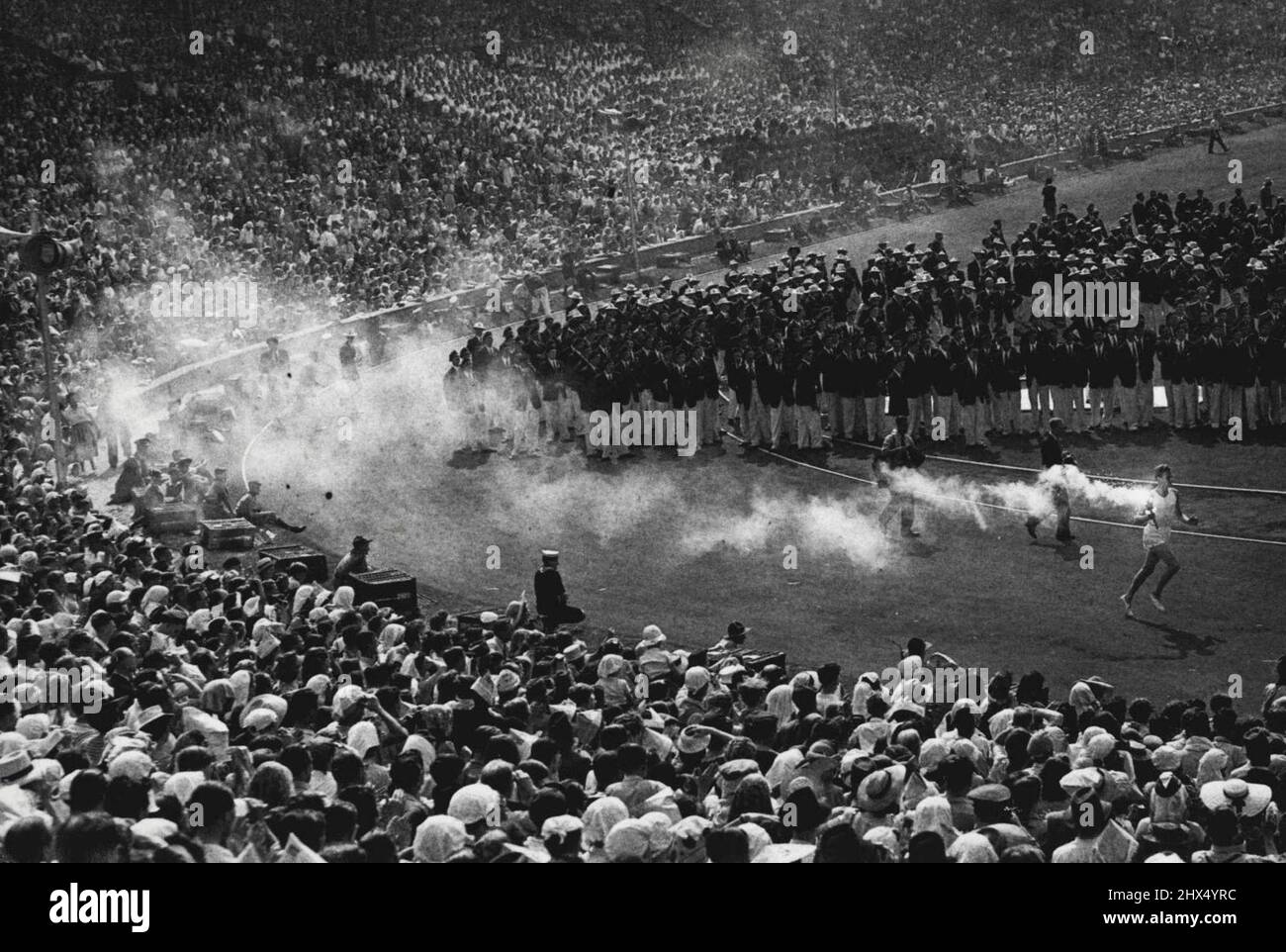 Die Flamme erreicht das Ende ihrer Reise: John Mark, der geheimnisvolle Fackel - Träger, trägt die olympische Flamme auf der letzten Etappe seiner 200 Meilen langen Reise von Griechenland aus durch die Arena in Wembley, bevor er die Schale anzündet, in der die Flamme bis zum Ende der Spiele brennen wird. John Mark wurde als Personifizierung der sportlichen Jugend des Landes ausgewählt. 29. Juli 1948. Stockfoto