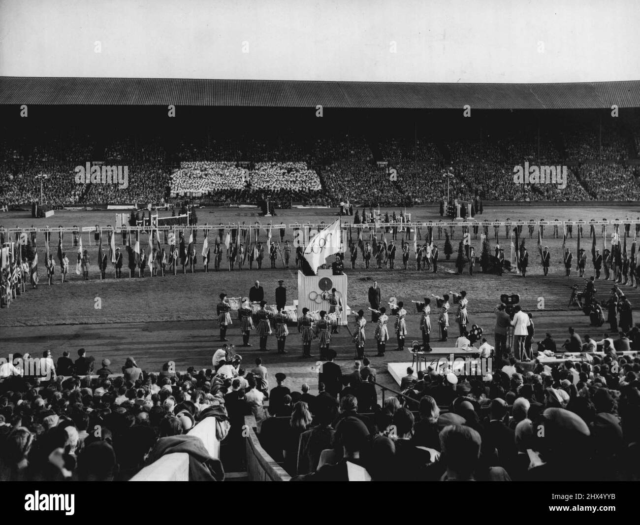 Abschluss des Spiels der XIV. Olympiade : Eine allgemeine Ansicht des Abschlusses der Spiele der XIV. Olympiade im Wembley Stadium, London, Aug. 14. Im Vordergrundzustand klingen Trompeter eine Fanfare. Auf der Tribüne der Ehre ist Sir Frederick Wells, Oberbürgermeister von London, zu sehen. (Von Flag verdeckt ist J. Sigfrid Edstrom, Präsident des Internationalen Olympischen Komitees). Rechts von der Tribüne steht Lord Burghley, Vorsitzender des Organisationskomitees. Hinter der Tribüne werden die Flaggen der konkurrierenden Nationen vorgeführt. 14. August 1948. (Foto von Olympic Photo Association). Stockfoto