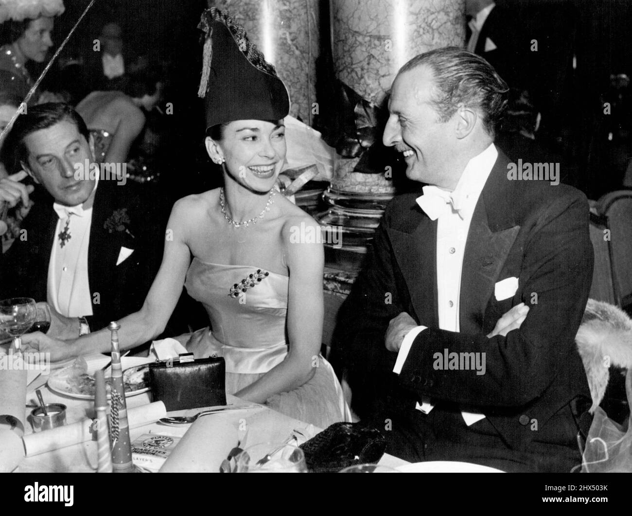 Krönungsball im Savoy - Ballerina Margot Fonteyn trug gestern Abend beim Ball einen Hut in einem schicken Kleid mit Satin- und Tüllkleid. Sie hat sternförmige Ohrringe und eine passende Halskette mit einer Brosche mit Blattmuster auf ihrem Kleid. 03. Juni 1953. (Foto von Evening Standard Picture). Stockfoto