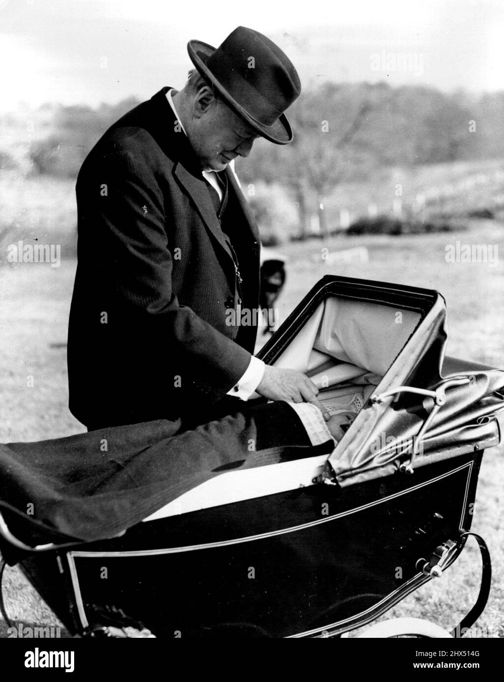 Churchills fünftes Enkelkind, das das neu getaufte Baby getauft hat, kommt von seinem berühmten Großvater zur Aufmerksamkeit, als er auf der Taufparty, die dem Gottesdienst in Westerham heute (Sonntag) folgte, in seinem Kinderwagen liegt. Herr und Frau Winston Churchill waren heute (Ostersonntag) in der Westerham Church, Kent, zur Taufe ihres fünften Großfürsten Arthur Nichola Winston Soames, des ersten Kindes ihrer Tochter Mary, die im Februar 1947 mit Kapitän Christopher Soames verheiratet war, anwesend. 28. März 1948. (Foto von Reuterphoto). Stockfoto