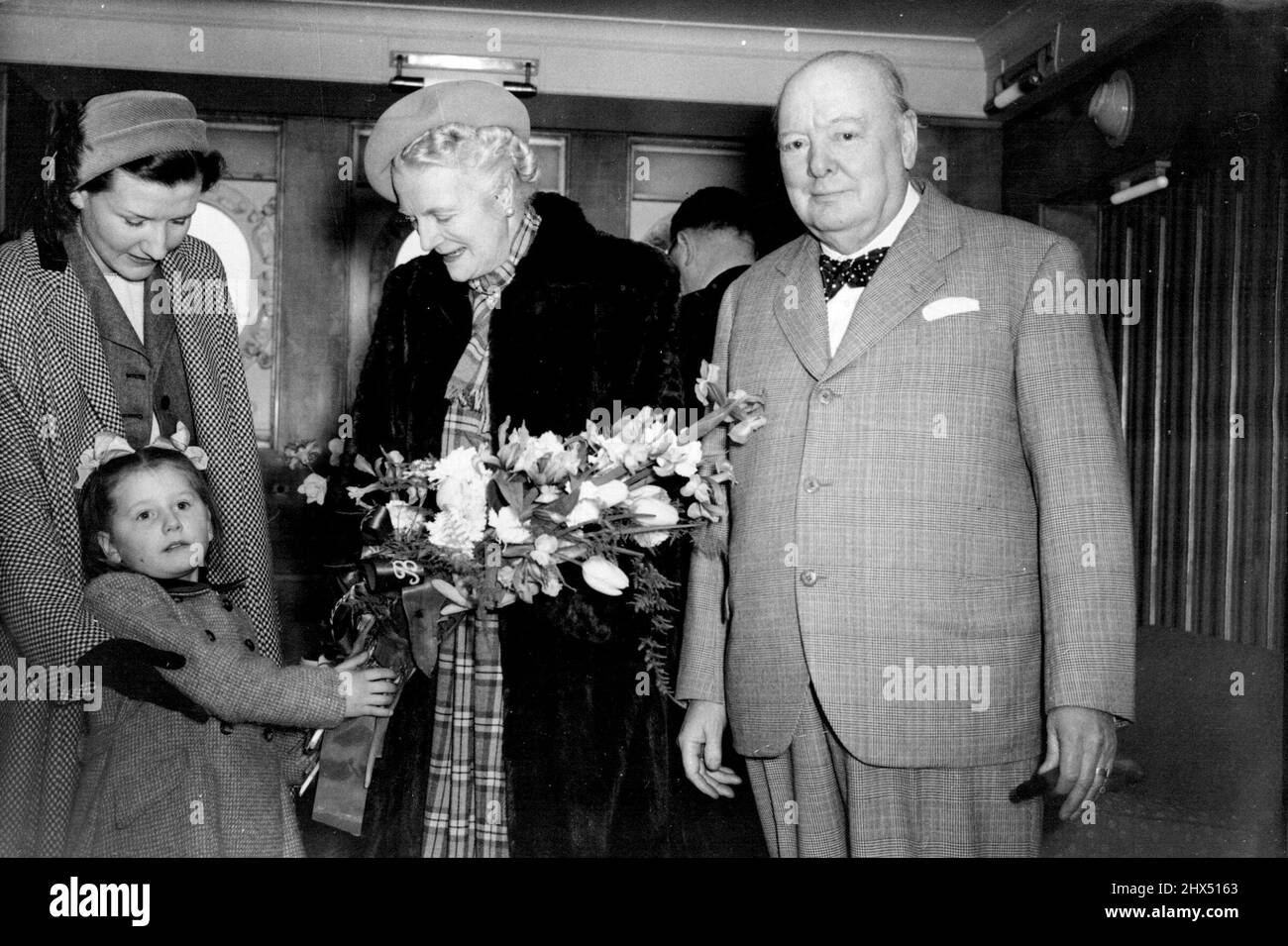 Blumenstrauß für Frau Churchill Frau Churchill wird von der 5-jährigen Mary Gay Bembridge, Tochter des konservativen Kandidaten für Southampton, mit einem Blumenstrauß überreicht. Bevor der Cunard White Scar-Liner Queen Elizabeth von Southampton nach New York abfuhr, fährt heute (Freitag) Herr Churchill an der Seite seiner Frau mit Frau Churchill nach Amerika, um eine Ansprache an die Mitglieder des Maassäusetts Institute of Technology in Boston zu halten. Er besucht auch privat Washington und New York. 18. März 1949. (Foto von Reuterphoto). Stockfoto