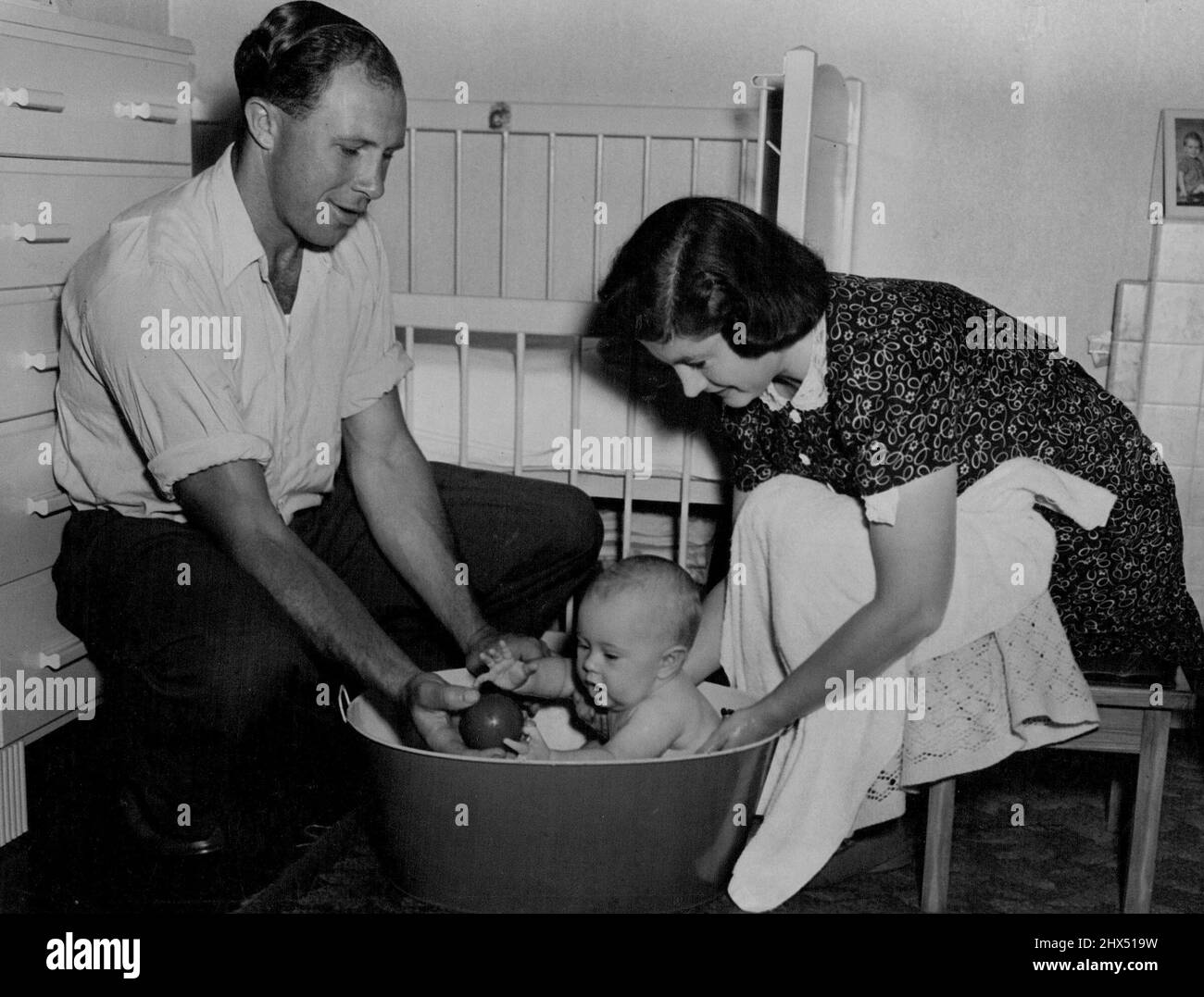 Bob ist nie weit entfernt von dem jungen Bruce, wenn er zu Hause ist, und spielt sogar mit dem Jungen, wenn er im Bad ist. 01. Juni 1948. Stockfoto