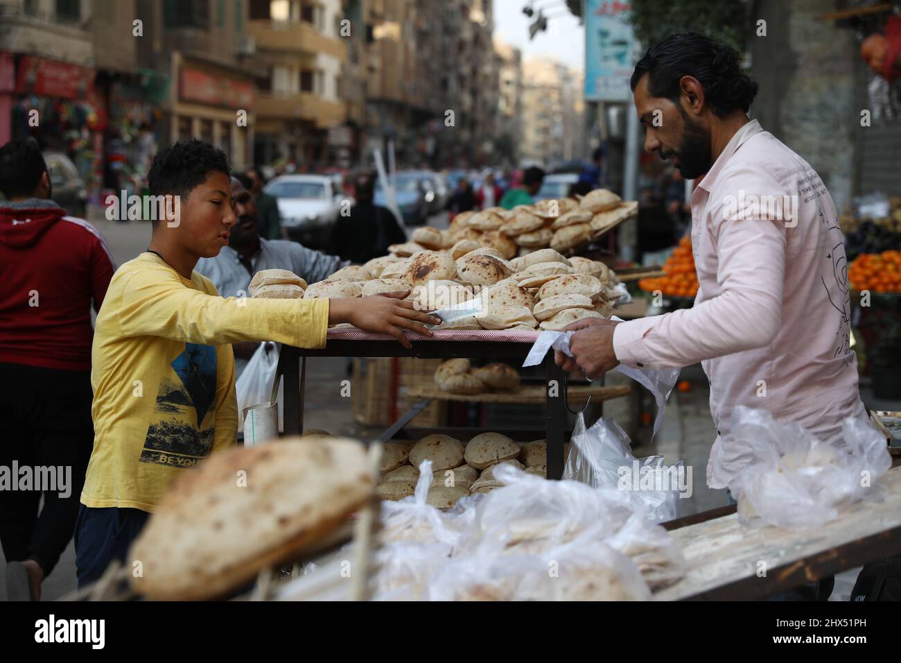 Kairo, Ägypten. 9. März 2022. Ein Junge kauft am 9. März 2022 auf einem Markt in Kairo, Ägypten, Brot. Der ägyptische Premierminister Mostafa Madbouly hat am Mittwoch zugesagt, die Lebensmittelpreise inmitten des anhaltenden Konflikts zwischen Russland und der Ukraine in einem fairen Bereich zu halten. Quelle: Ahmed Gomaa/Xinhua/Alamy Live News Stockfoto