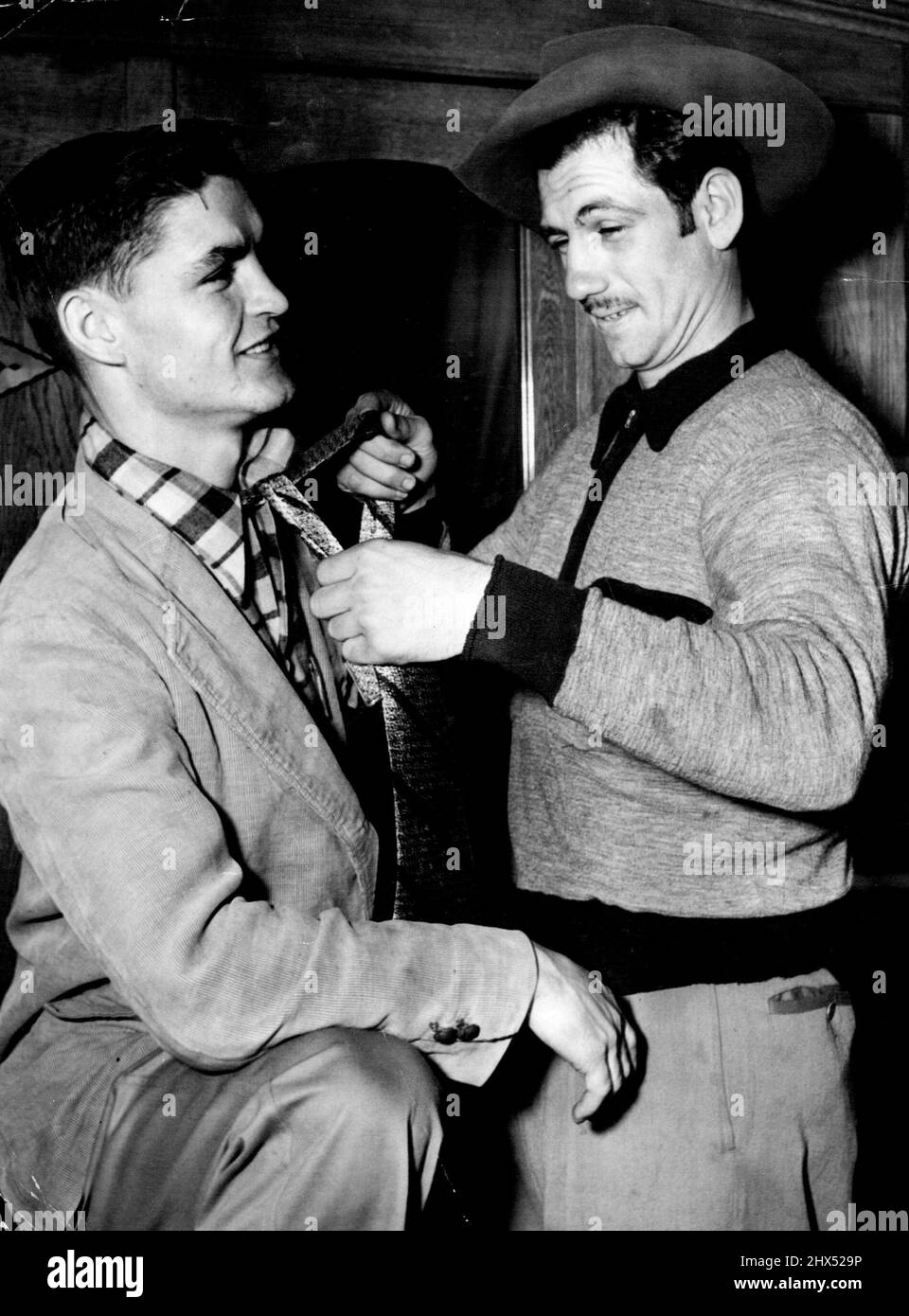 „Ich kann das nicht besonders gut“, sagt Bronco Don Johnson, als er versucht, eine Krawatte für seinen Freund American bantam Johnny O'Brieri Johnson zu knüpfen, der morgen Abend im Sydney Stadium gegen Len Dittmar kämpft, sagt, er habe nur einmal eine Krawatte bei seiner Hochzeit getragen. 27. April 1952. Stockfoto