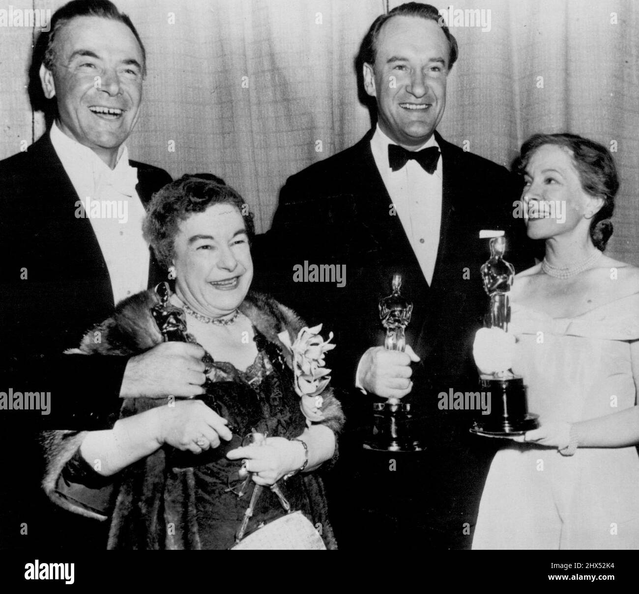 Oscar-Prinzipale -- Josephine Hull (links vorne), George Sanders (hinten rechts) und Helen Hayes halten Oscar-Verleihung, die sie gestern Abend bei der Zeremonie erhielten. Miss Hull gewann die beste Nebendarstellerin für „Harvey“. Sanders wurde für „All About Eve“ als bester Nebendarsteller ausgezeichnet. Miss Hayes nahm die Auszeichnung für Jose Ferrer, den besten männlichen Schauspielgewinnerin, der in New York ist, entgegen, und Dean Jagger (links) übergab die formelle Präsentation an Miss Hull. 30. März 1951. (Foto von AP Wirephoto). Stockfoto