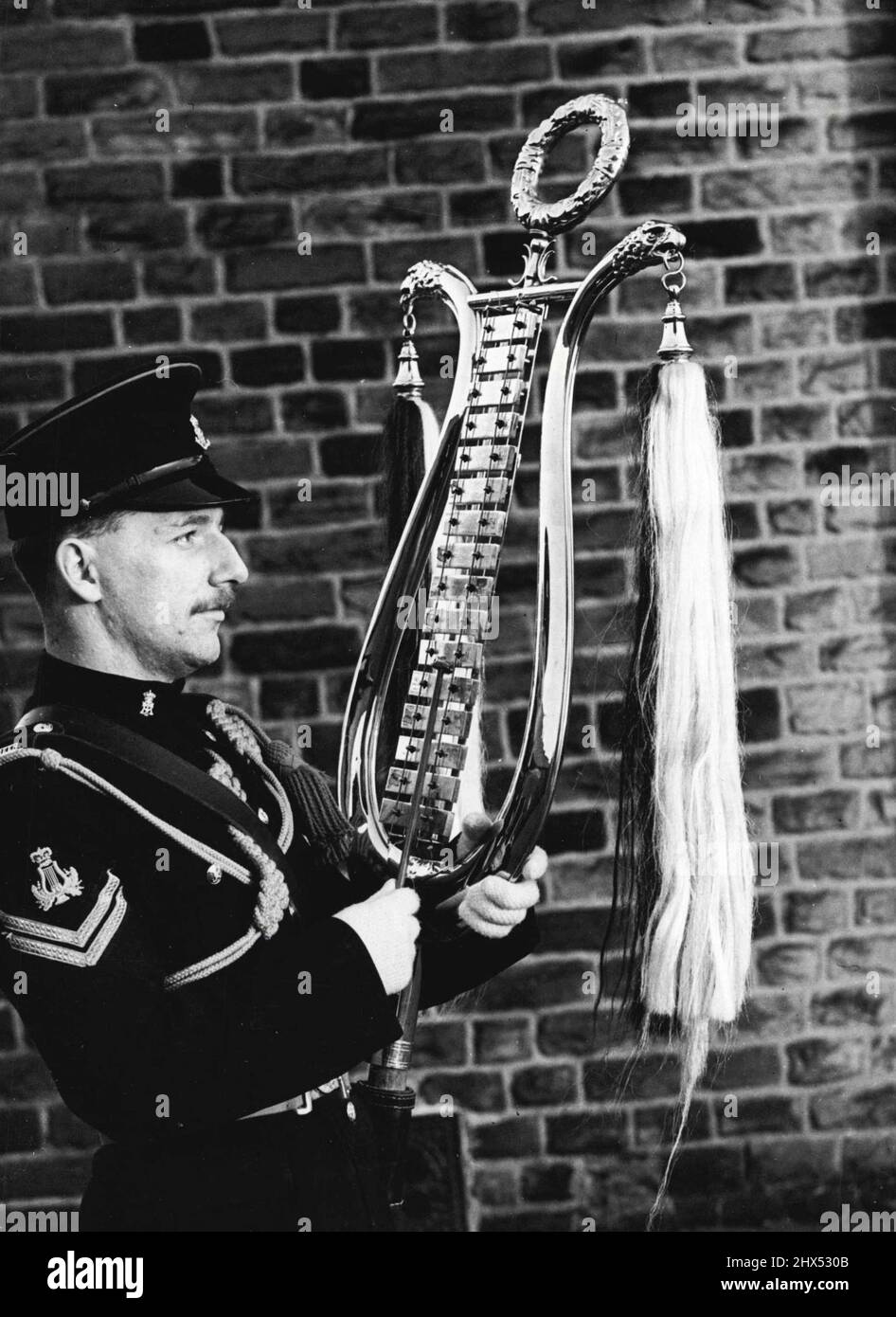 Das Grüne ***** Adoptieren Sie das Glockenspiel, das auf ***** wartet Parade mit der Band der Grünen ***** Regiment ist Corporal H. Mett aus Freetwood, mit einem Instrument, das selten in britischen Militärbands zu sehen ist. Es ist ein Glockenspiel und ähnelt einer Xylophona mit Metalltasten. Die Band sah, dass es in amerikanischen und deutschen Bands gespielt wurde, als sie kürzlich eine Dienstreise in Deutschland machten und beschlossen, eine für sich zu besorgen. Korporal Mett hat schnell gelernt, es zu spielen und es fügt der Musik eine unverwechselbare Note hinzu, wenn die Biegung der grünen Howards auf Parade ist. 6. Dezember 1955. (Foto von Reuterphoto). Stockfoto