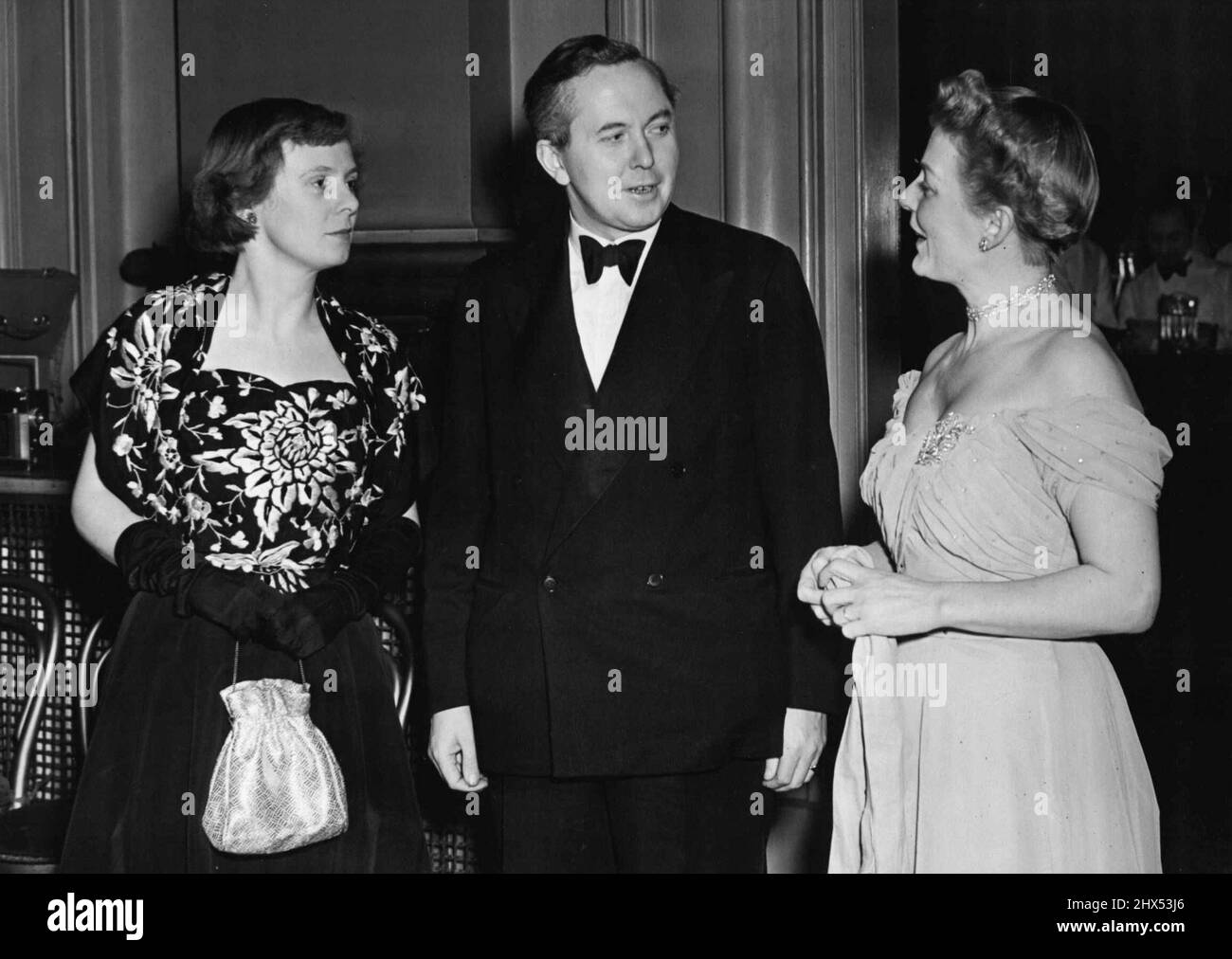 Gala Ballet Im Royal Opera House, Covent Garden -- Herr Harold Wilson, Präsident des Board of Trade, mit seiner Frau (links) in einem schwarzen, silberfarbenen Kleid und Frau Digby Morton in edwardianischem Moonshine Blue-Kleid.Käufer aus der ganzen Welt kommen diese Woche an, um die Frühjahrskollektionen des Londoner Modehauses zu sehen. Am Royal Opera House. Covent Garden, an diesem Abend, unterhielt die Incorporated Society of London Fashion Designers die Besucher. Die Gesellschaft hat die Grand Tier für die abendliche Ballettaufführung gebucht und eine Abendparty im Theater veranstaltet. 26. Januar 1950. (Foto von Fox Photos) Stockfoto