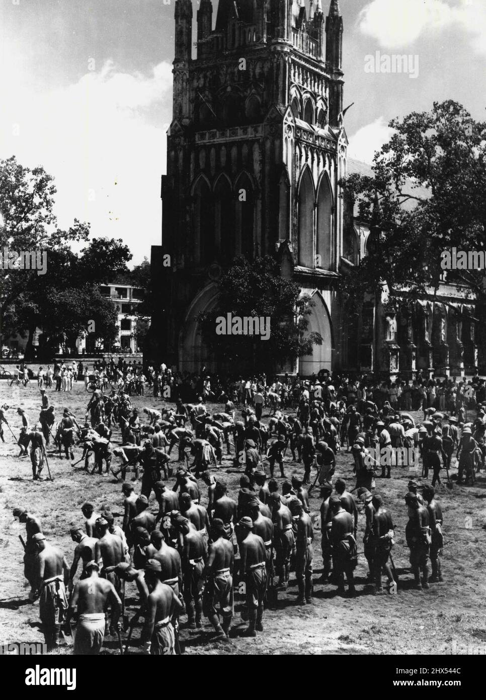 Japanische Kriegsgefangene, die von indischen Truppen bewacht werden und Luftangriffsgräben auf dem Gelände der St. Andrews Cathedral ausfüllen. 11. September 1945. (Foto vom Australian war Memorial) Stockfoto