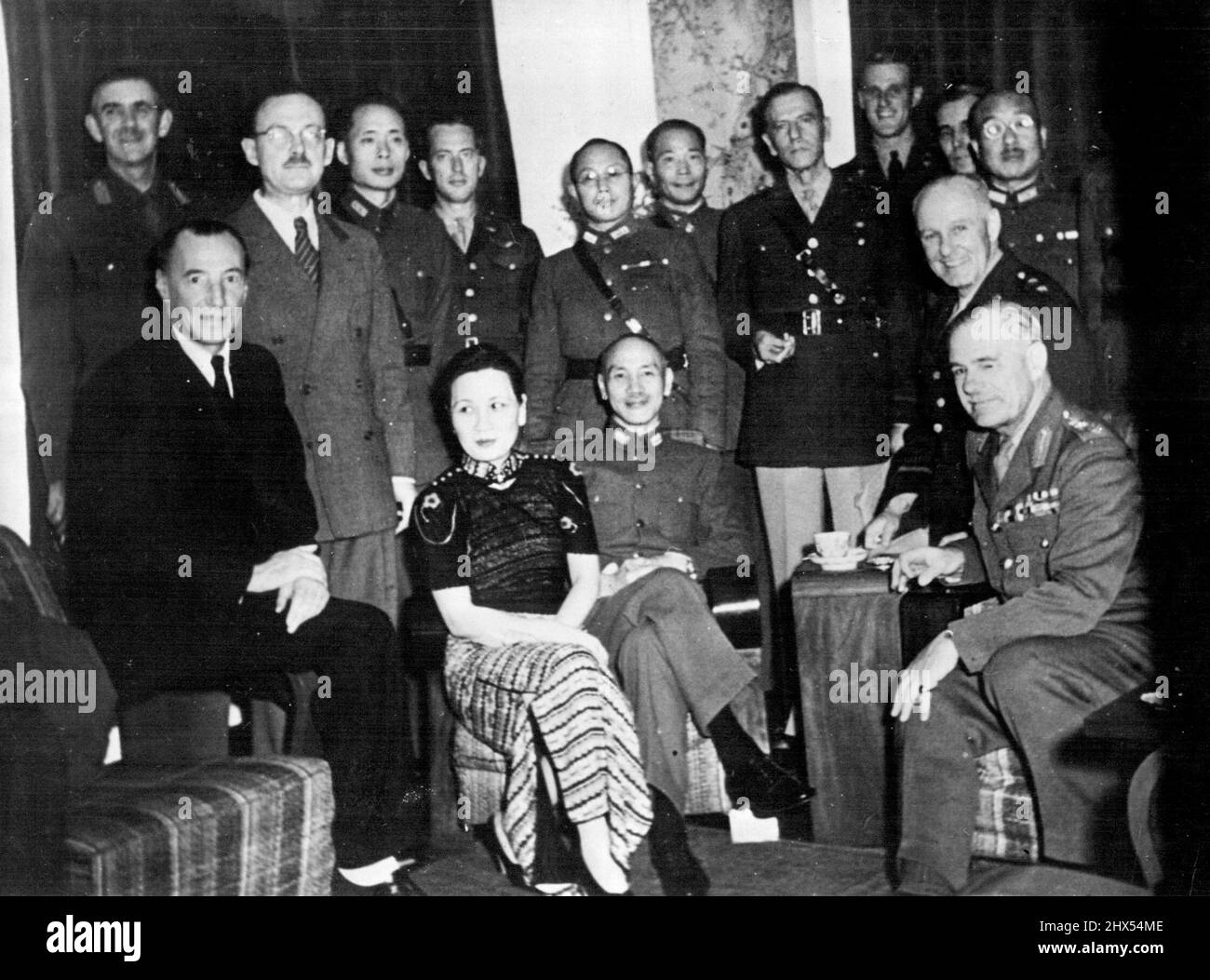 Generalissimo und Madame Chiang Kai-Shek empfangen General Sir Archibald Wawell und Lieut-gen, George Brett, Oberbefehlshaber bzw. stellvertretender Oberbefehlshaber der alliierten Streitkräfte im Südwestpazifik, bei ihrem jüngsten Besuch in Chungking, um mit dem Generalissimo über das alliierte Kommando, von links nach rechts, sitzend, Sir Archibald Clark Kerr, Botschafterin in China bis Januar 1942, jetzt Botschafterin in der UdSSR, Madame Chiang, Generalissimo Chiang, Lieut-Gen. Brett, General Wavell 1/2 hinter Sir Archibald Kerr steht General Lancelot Dennys, Leiter der britischen Militärmission nach China; dazwischen Stockfoto