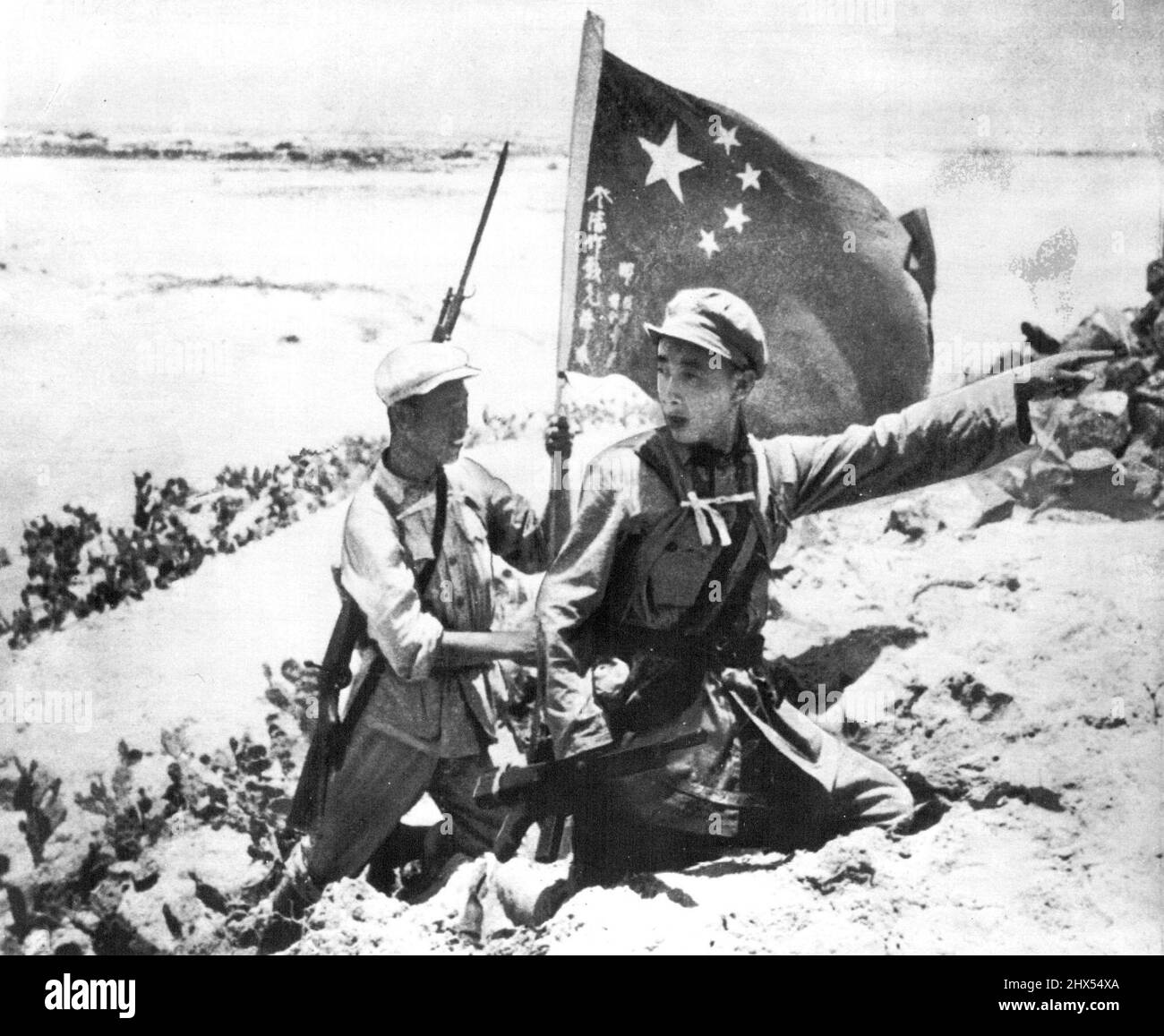 Rote Truppen Auf Der Insel Hainan -- Dieses Bild der Invasion der Insel Hainan vor der Südküste Chinas Mitte April wurde von einem Fotografen aufgenommen, der mit den chinesischen Reds an Land ging und beschrieben wird, als er rote Soldaten zeigt, die an einem Strand auf der Nordseite der Insel aufmarschierten. Eine trägt die chinesische kommunistische Flagge. Bild, das heute per Flugzeug nach New York kam, wurde Wochen nach der Invasion in Hongkong verfügbar. 7. Juli 1950. (Foto von AP Wirephoto). Stockfoto