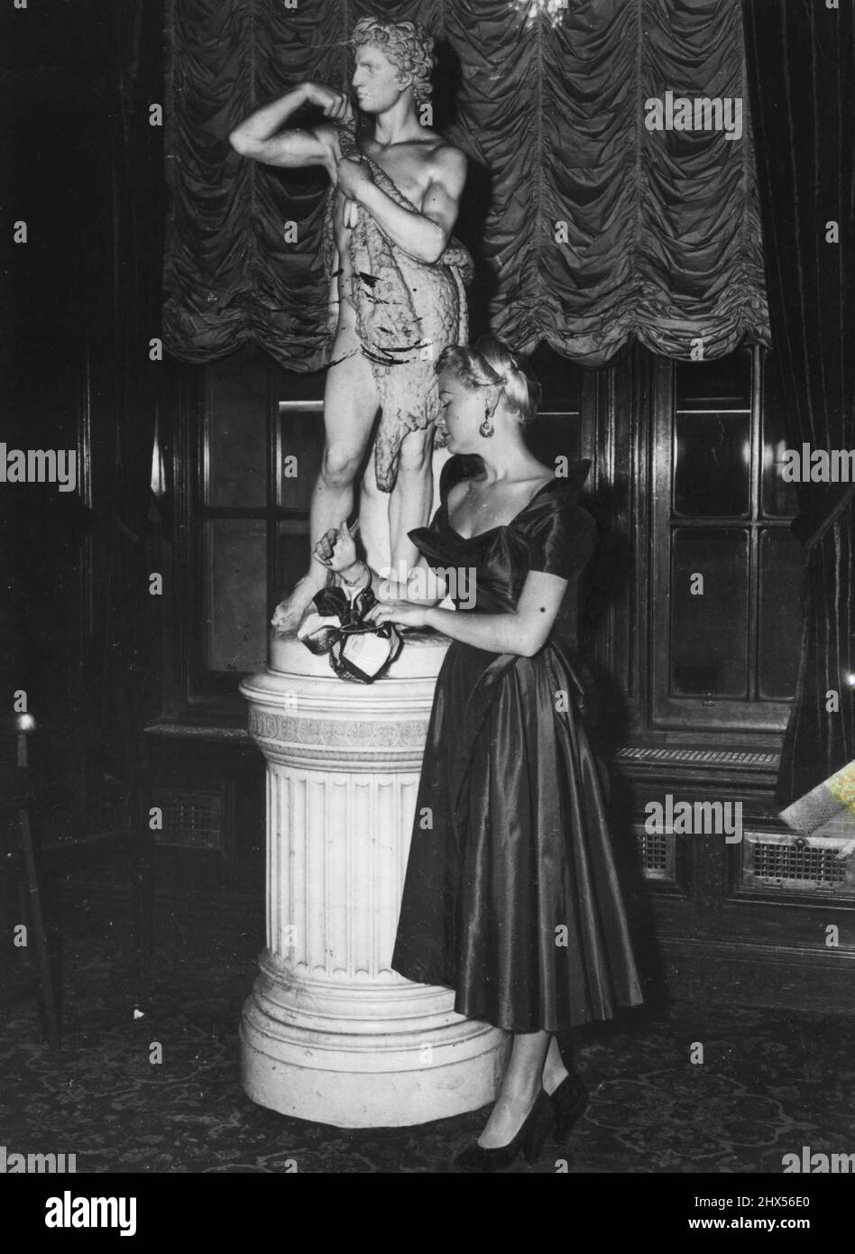 Das Cell Chapman-Kleid aus Nylon ist in leuchtendem Kohlerot gehalten und hat einen Rock mit Blumendruck. 17. März 1952. Stockfoto