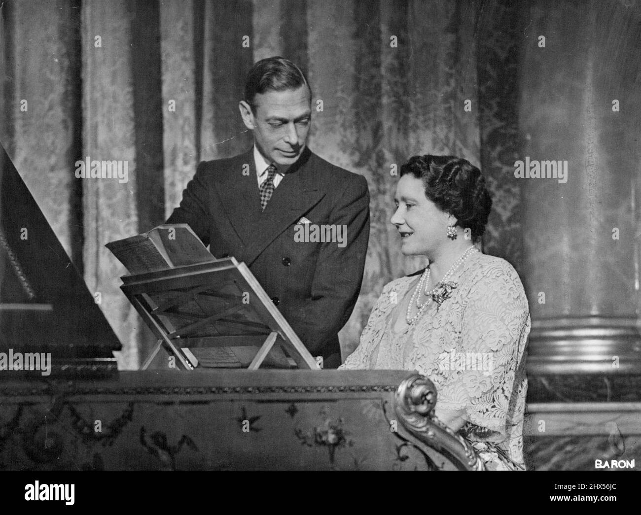 Ihre Majestäten König George VI. Und Königin Elizabeth Royal Silver Wedding Foto -- Eine charmante Studie des Königs und der Königin im blauen Salon im ersten Stock des Buckingham Palace aufgenommen. The Queen spielt das bekannte Lied „The Toast“. 20. April 1948. (Foto von Baron, Cmera Press) Stockfoto