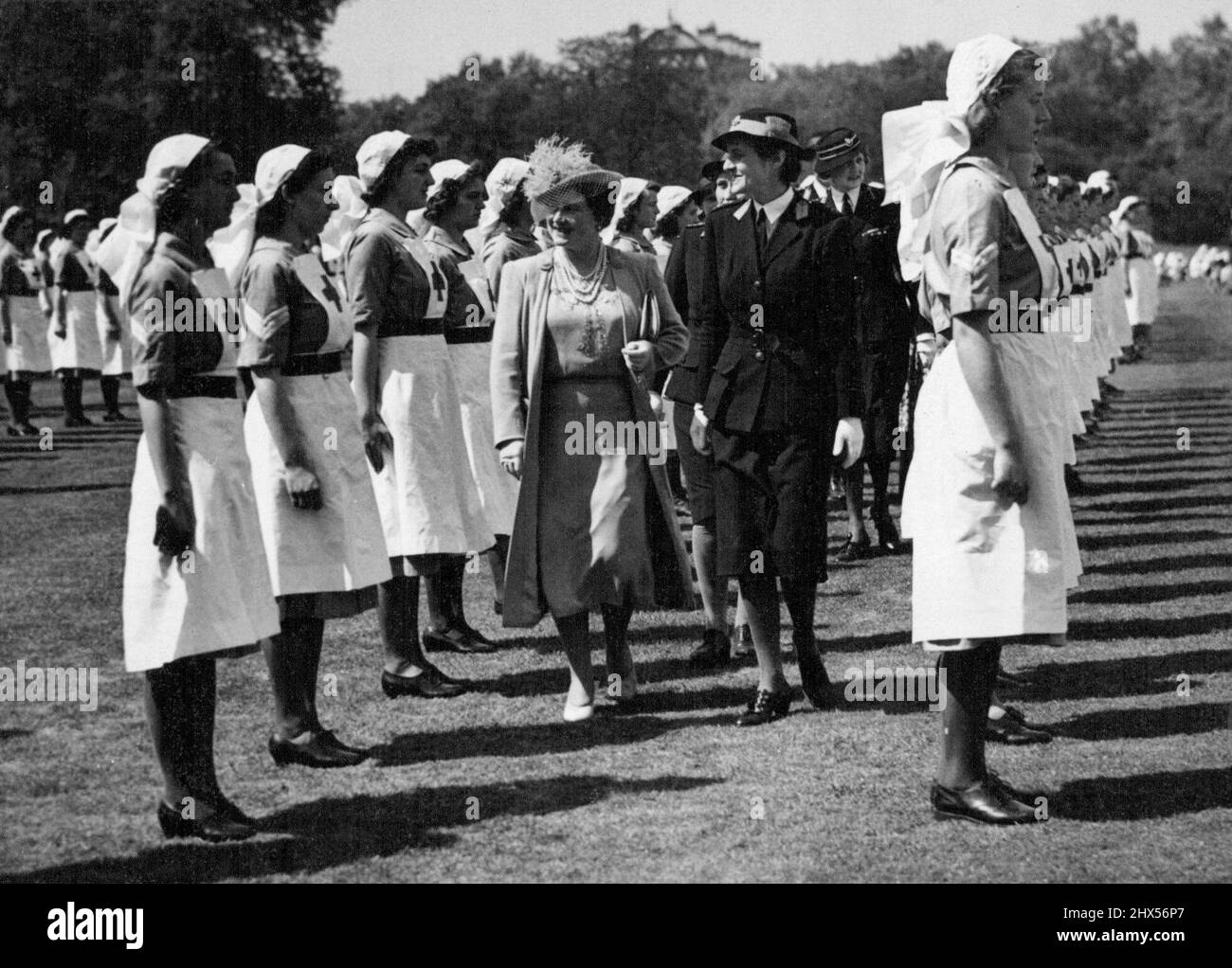 Die Königin inspizierte Mitglieder der Junioren des Roten Kreuzes -- Herr Majestät die Königin inspizierte am 16.. Mai eine Parade der Jugendabteilungen der Britischen Rotkreuzgesellschaft und der Kadettenabteilungen der St. John Ambulance Brigade im Buckingham-Palast und nahm am Vormarsch den Gruß. Die Königin inspiziert Juniormitglieder der Rotkreuzgesellschaft. 01.Mai 1943. Stockfoto