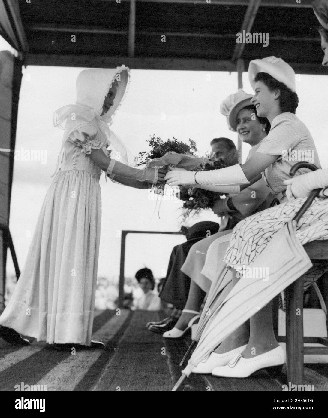 Strauß für die kleine Prinzessin Rona Pretorius, acht Jahre alt, übergibt Prinzessin Elizabeth einen Strauß in Pietersburg, Südafrika. Die königliche Familie flog mit ihrem Wikingerflugzeug von Pretoria aus, um den Tag in Pietersburg, der Hauptstadt des nördlichen Transvaal, Südafrika, zu verbringen, wo sie an einem Treffen von Schulkindern teilnahmen. 9. April 1947. (Foto von Planet News) Stockfoto