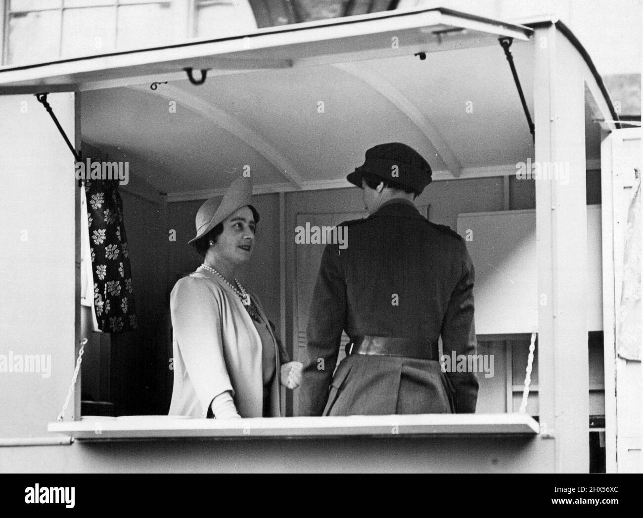 Queen inspiziert Frauenlegion - die Queen inspiziert das Innere einer mobilen Kantine, die L.D.V.S. im Nachtdienst bedient. Einmal wöchentlich bohren uniformierte Frauen im Royal Mews, im Buckingham Palace, London, und gestern Abend wurden sie von der Queen inspiziert. Sie sind Mitglieder der Frauenlegion. Sie sind Mitglieder der Frauenlegion, dem berühmten Korps, das 1914 gegründet wurde. Die Frauenlegion ist ein freiwilliges Korps, das seit seiner Gründung im Jahr 1914 in die Armeeliste aufgenommen wurde. 24. Oktober 1940. (Foto: Fotos der Londoner Nachrichtenagentur). Stockfoto