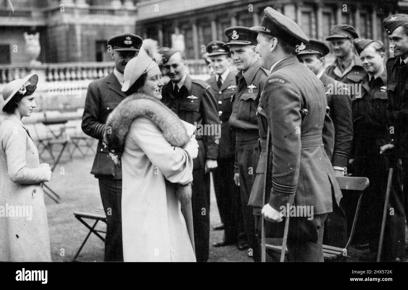 Royal Empire Day Garden Party zu Repatriierten Kriegsgefangenen im Buckingham Palace. Die Königin wird mit Radameyer aus Bukawaye, Süd-Rhodesien, Afrika, gesprochen, der im Juni letzten Jahres niedergebracht wurde, indem er sich beim Ausballen das Bein verletzte, weil das Deutsche Krankenhaus die Vernachlässigung des Beins hatte und trotzdem sein Bein amputiert werden musste. Er ist sehr glücklich und hatte seitdem geheiratet.der König und die Königin heute, Empire Day, gab eine Gartenparty, um die Kriegsgefangenen des Imperium und des Dominion im Buckingham Palace zurückzuholen; sowohl der König als auch die Königin und die beiden Prinzessinnen zirkulierten kontrovertiert unter ihren Gästen ch Stockfoto