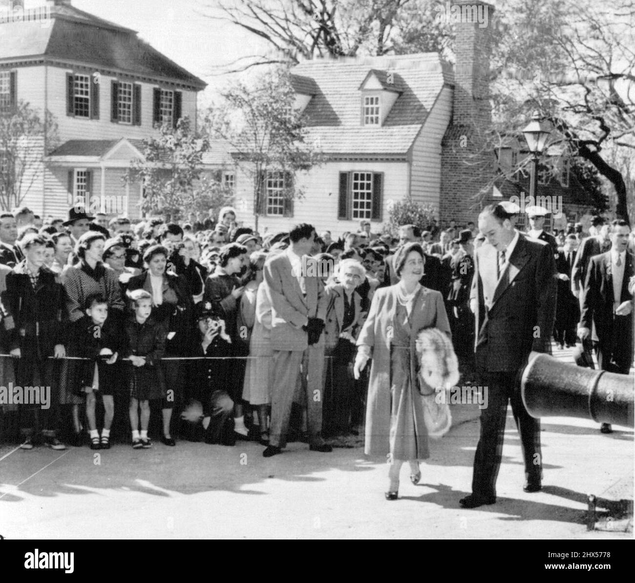 Queen Mother macht Einen Spaziergang - Queen Mother Elizabeth macht heute hier eine liebensliche Besichtigungstour durch die wiederversammelte Kolonialstadt. Ihr Gastgeber und Fremdenführer Winthrop Rockefeller, Vorsitzender des Vorstands von Colonial Wiliamsburg, zeigt ihr den Weg, wie sie sich dem Palast der Regierung über von Menschenmassen gesäumte Gehwege nähern. 11. November 1954. (Foto von AP Wirephoto). Stockfoto