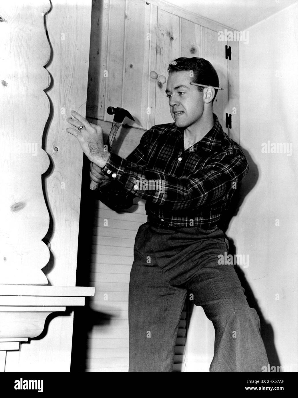 Zu Hause mit Richard Quine...Metro-Goldwyn-Mayer Schauspieler, der die junge Hauptrolle in „The Cockeyed Miracle“ spielt. Seine Zimmermannsarbeit erstreckt sich auf die Umgestaltung der Frühstücksecke. 25. August 1953. Stockfoto