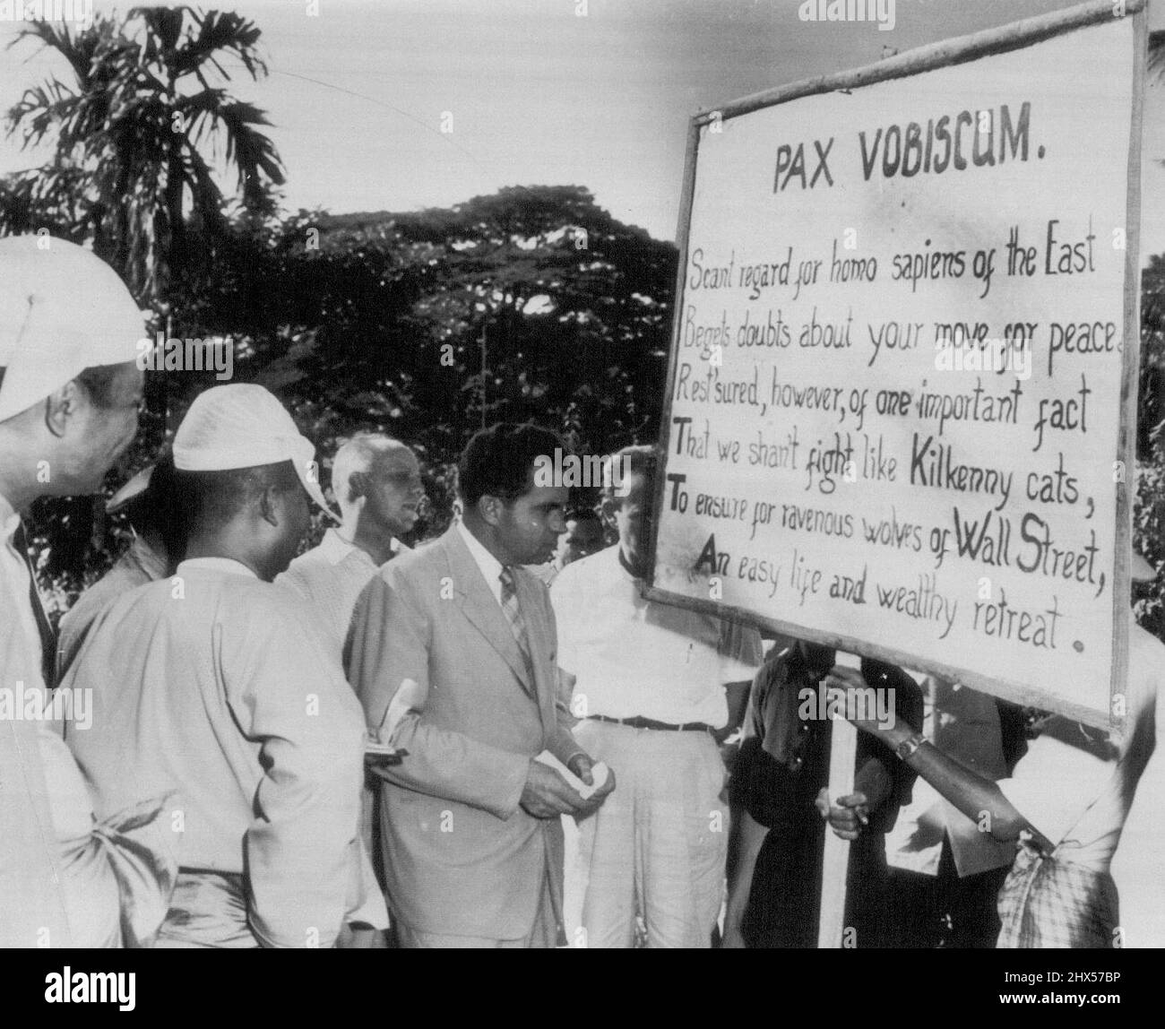 Nixon spricht mit antiamerikanischen Demonstranten -- Vizepräsident Richard M. Nixon, Mitte, blickt auf ein anti-amerikanisches Schild, das von linken Demonstranten am 26. November in Pegu, Burma, 40 Meilen nordwestlich von Rangun, gehalten wird. Nixon, der während seiner Weltreise durch die alte Stadt ging, bestand darauf, unter den Demonstranten zu laufen und mit ihnen zu sprechen. Seine Diskussion mit dem Führer der Versammlung war freundlich und es gab überall Handzittern, als Nixon ging. 05. Dezember 1953. (Foto von AP Wirephoto). Stockfoto